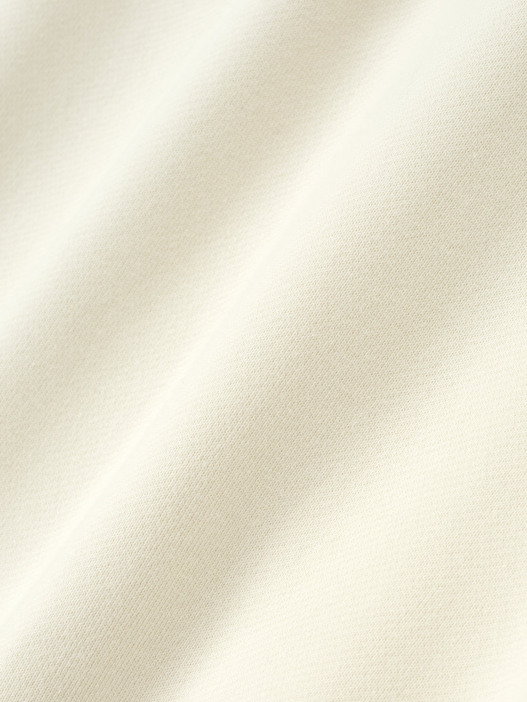 Close-up of cream white fabric texture from NBA 90s Hoodie showing soft knit and smooth surface detail
