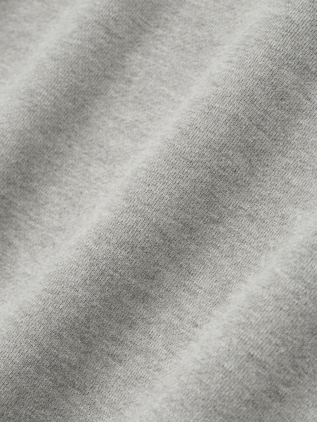 Close-up of concrete heather fabric texture from NBA 90s Hoodie showing soft knit detail and light gray color tone