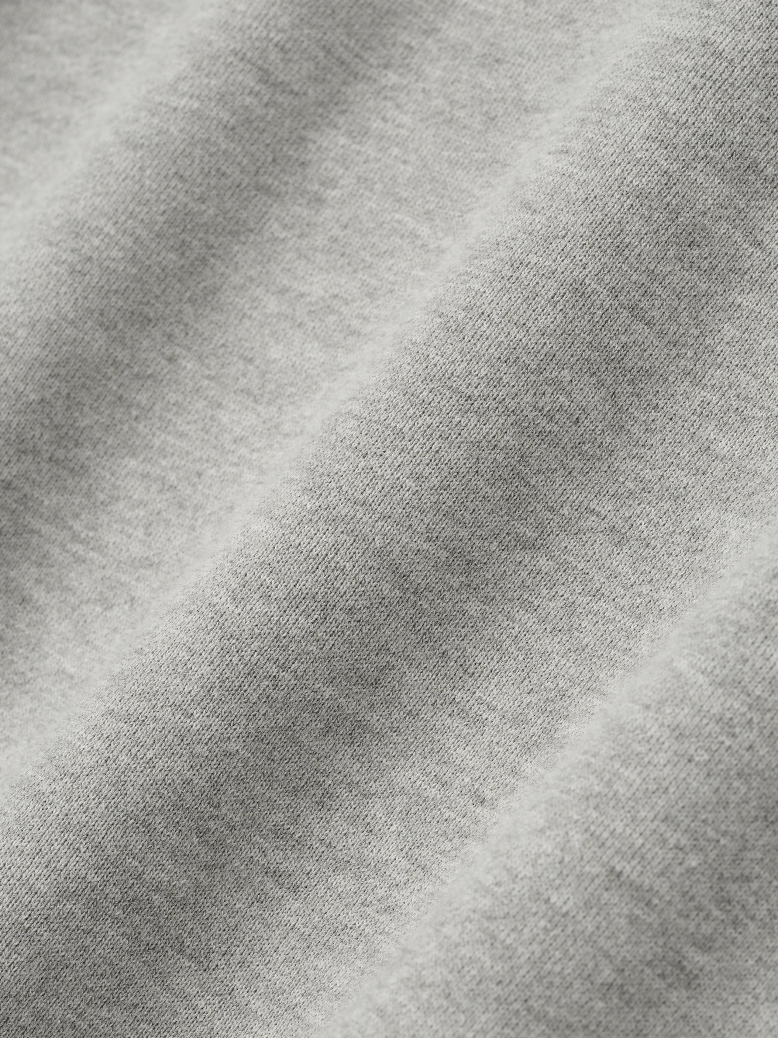 Close-up of concrete heather fabric texture from NBA 90s Hoodie showing soft knit detail and light gray color tone