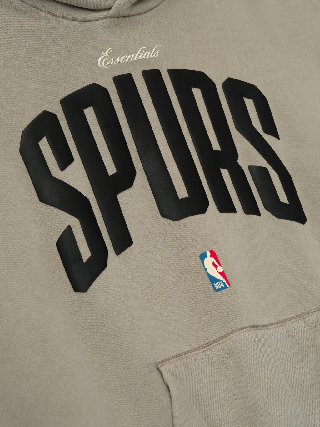 Close-up of beige Spurs 90s Hoodie front showing black arched team lettering and small NBA logo above kangaroo pocket, gallery image 0