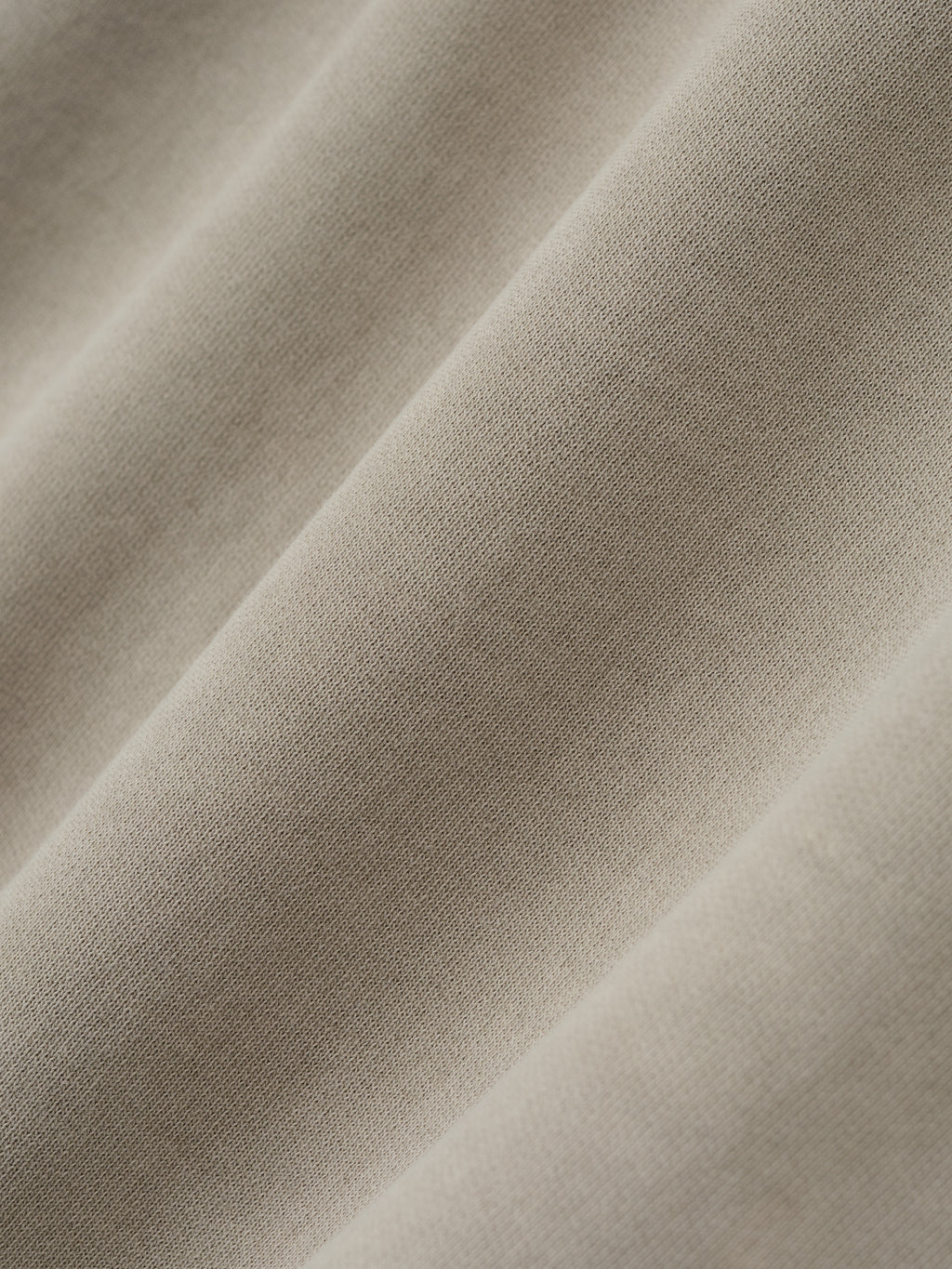 Close-up texture view of beige fabric detail from Spurs 90s Hoodie, gallery image 0, soft material folds visible