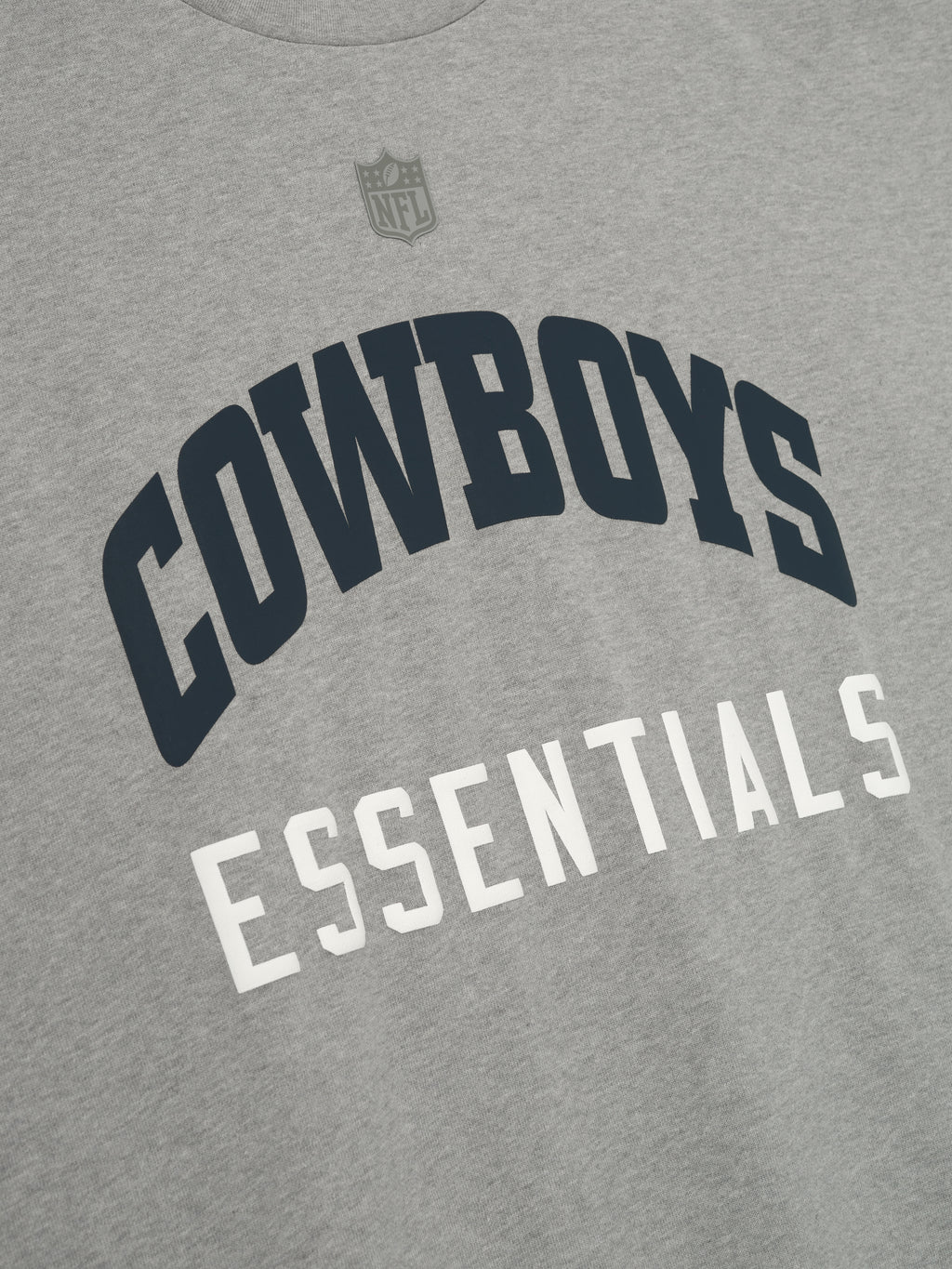 Close-up of concrete heather Cowboys 90s 3/4 Sleeve Football Tee showing arched navy Cowboys text and white Essentials below chest