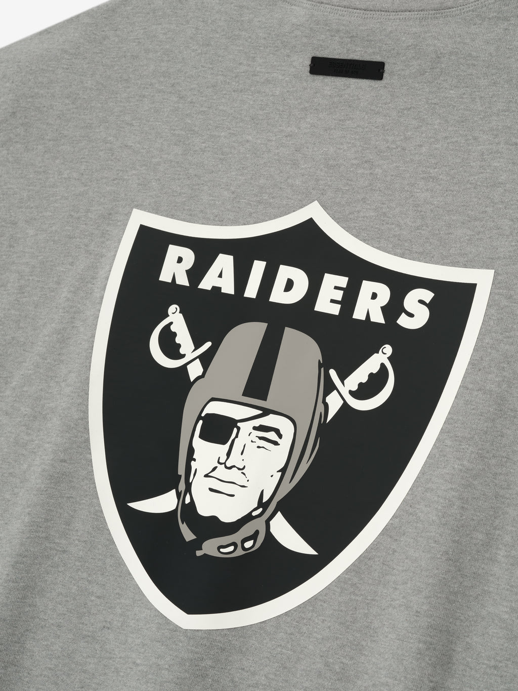 Close-up of concrete heather Raiders 90s 3/4 Sleeve Football Tee showing large classic Raiders shield logo on back center