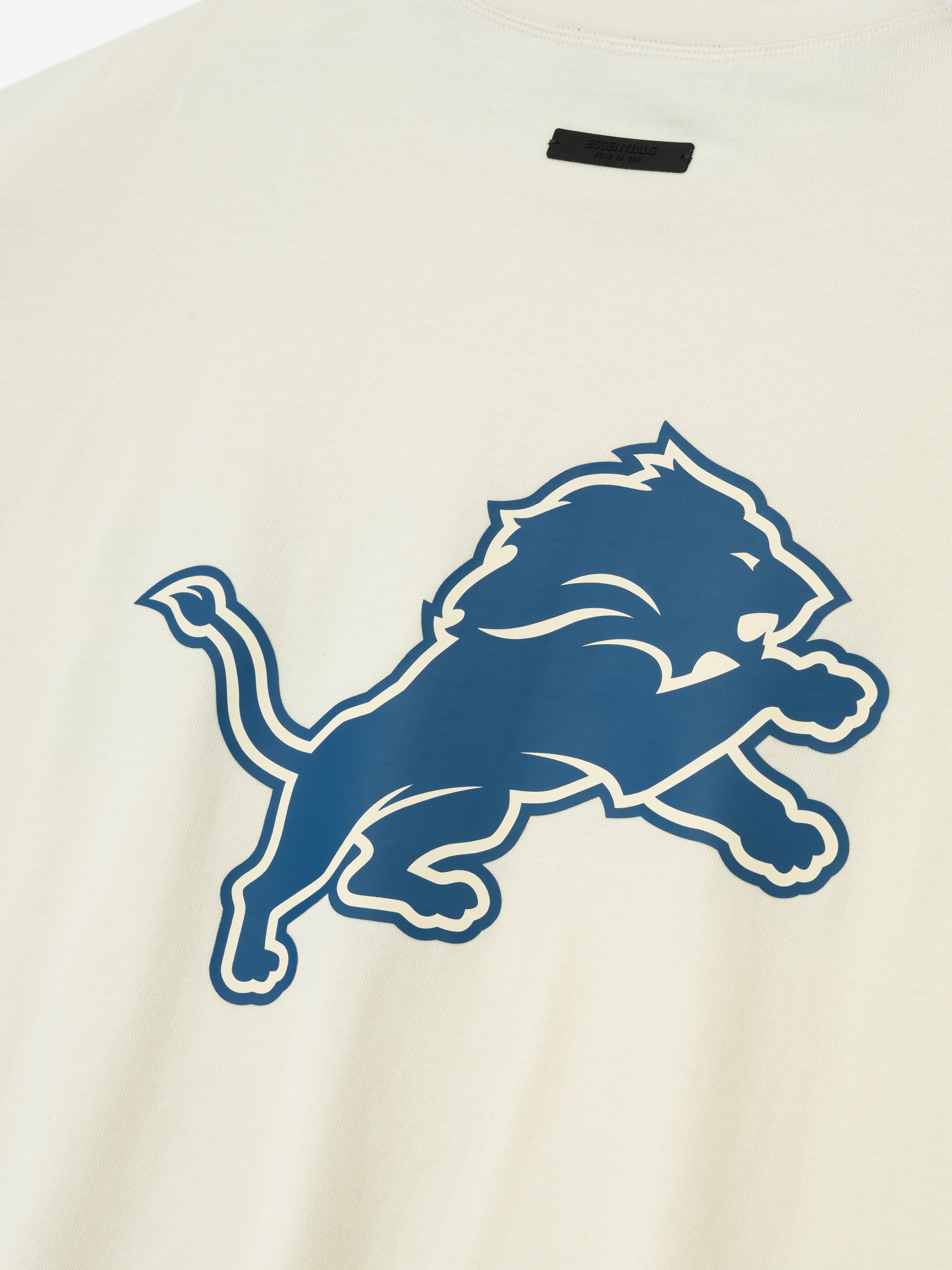 Close-up of cream white Lions 90s 3/4 Sleeve Football Tee showing large blue leaping lion graphic on front center