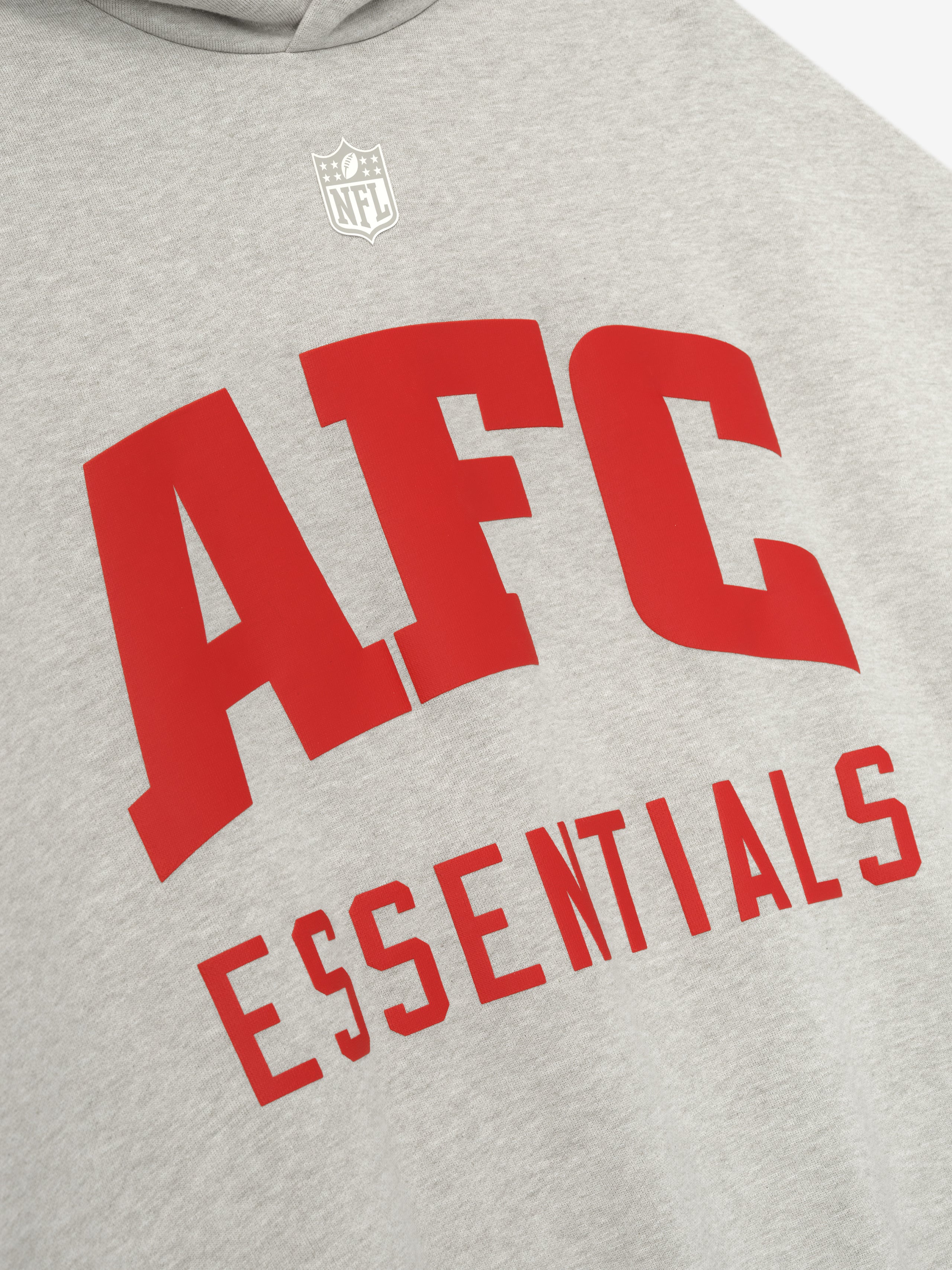 Heather stone American Sport Hoodie close-up showing large red AFC Essentials text and white NFL shield above the chest