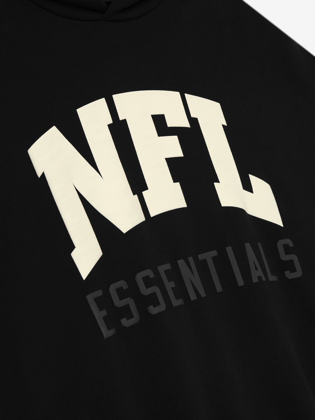 Close-up of black NFL Sport Hoodie with bold cream NFL text and subtle Essentials lettering on the front chest area