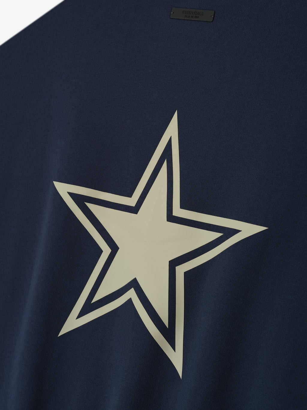 Dark navy fabric with a large cream star outlined in navy printed on the center of the garment
