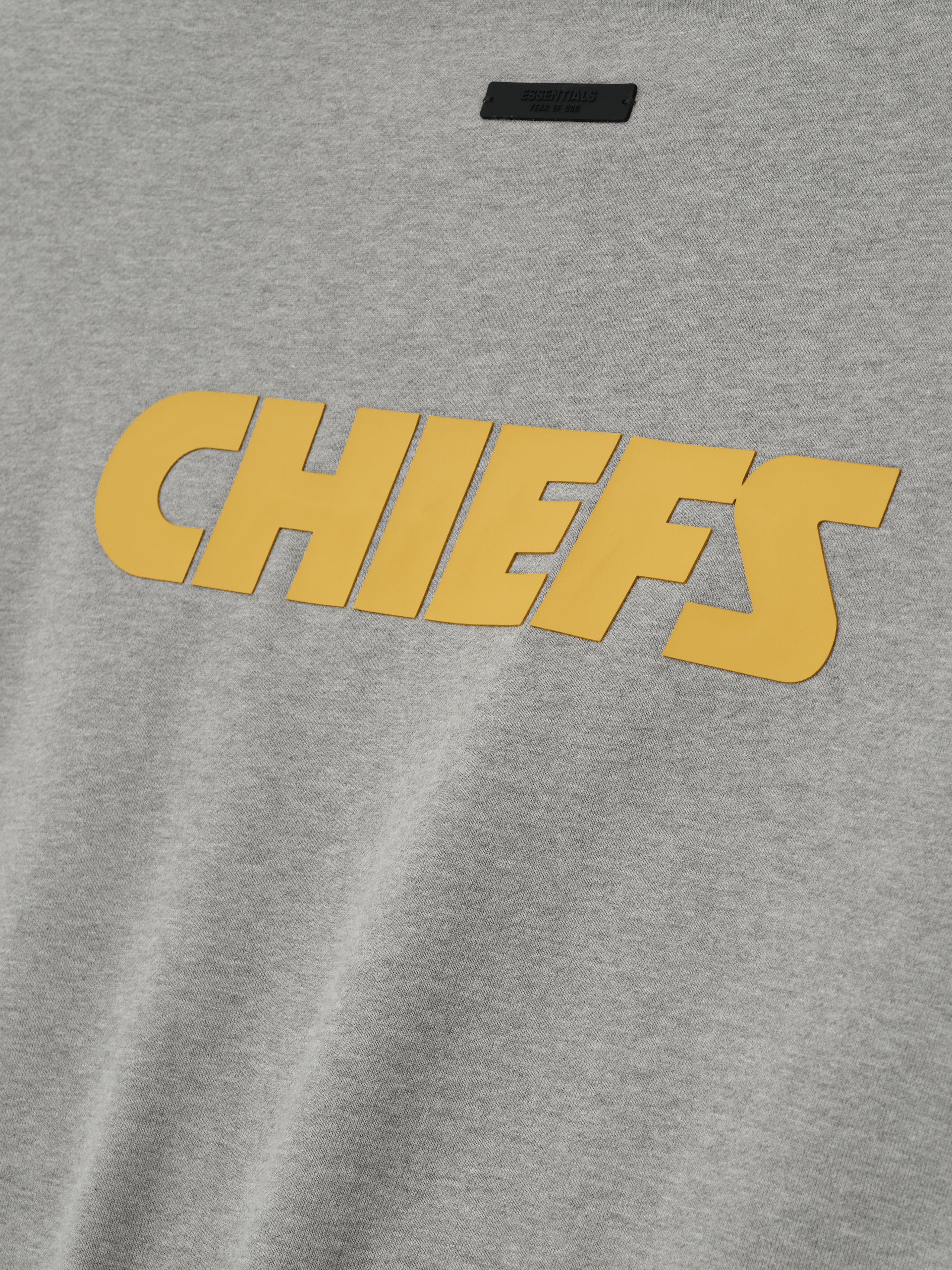 Close-up image of concrete heather Chiefs Sport Crewneck featuring large golden Chiefs text across front, gallery 0