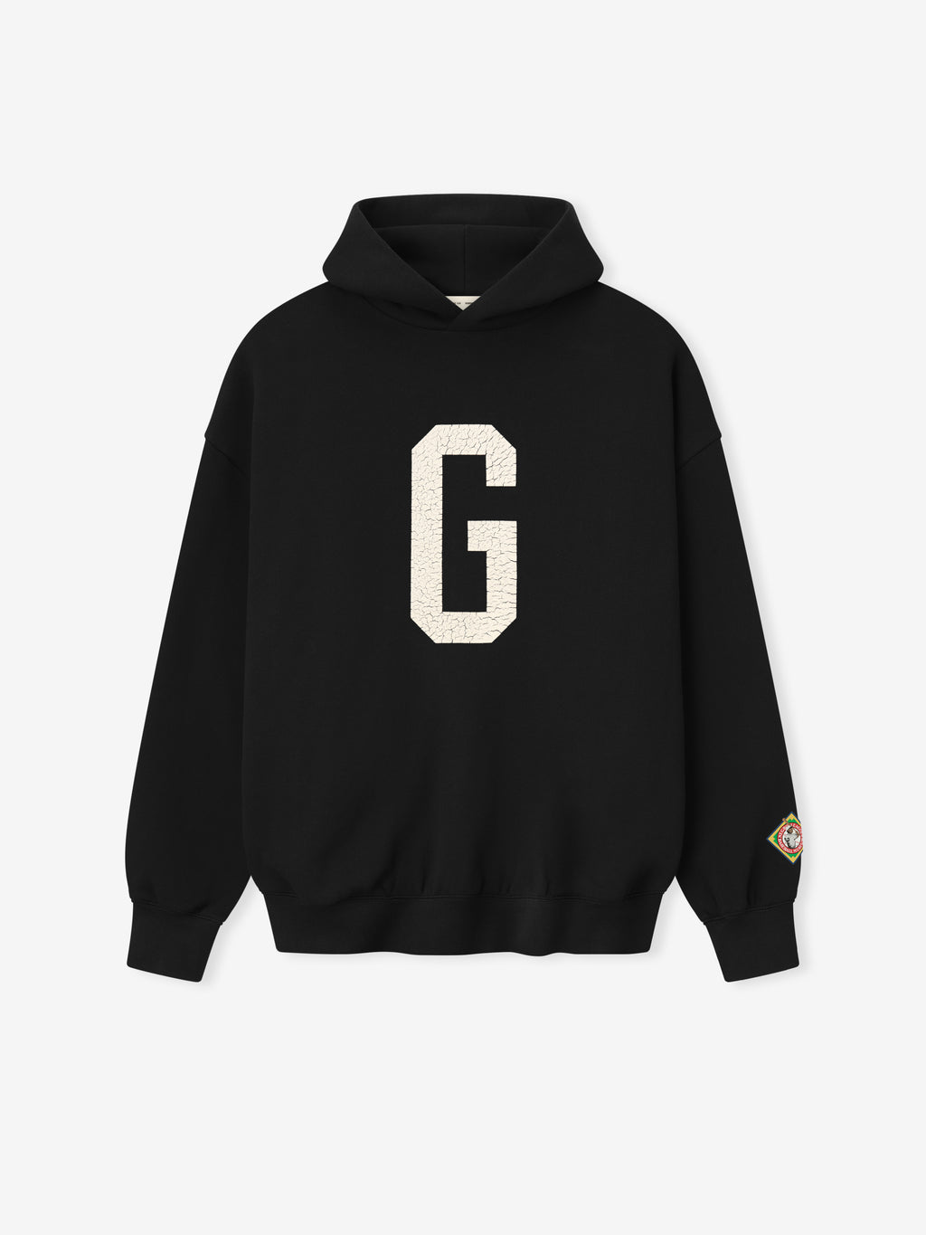 black Essentials hoodie with large white felt "G" graphic on front and colorful patch on left sleeve cuff