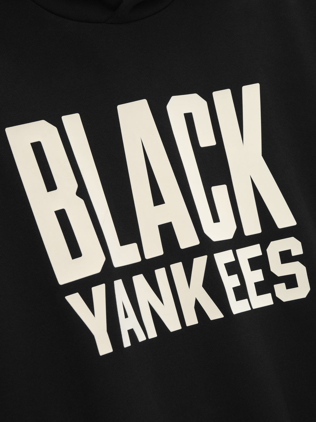 close-up of black hoodie front with large cream "BLACK YANKEES" text in bold block lettering