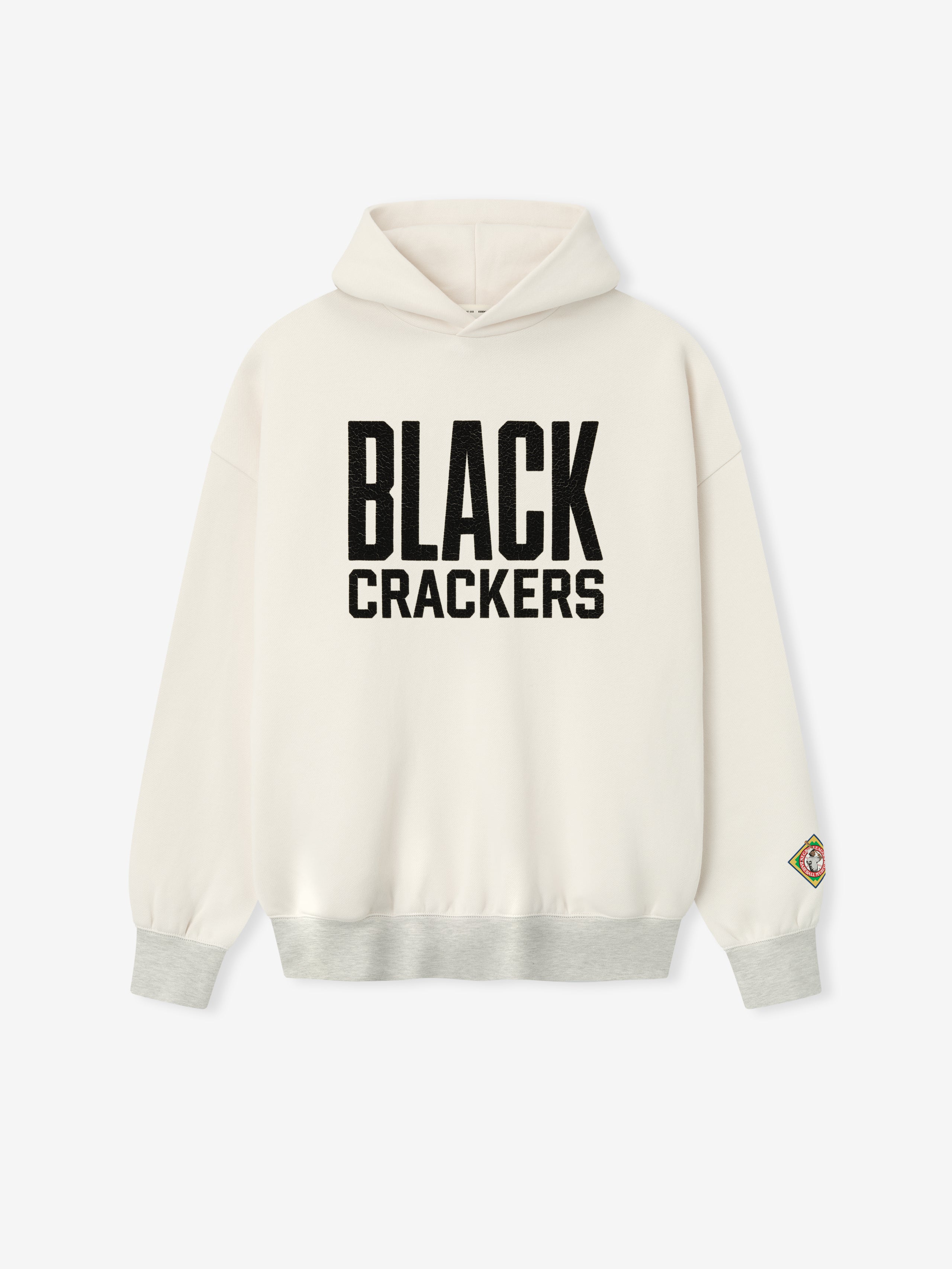 cream hoodie featuring bold black "BLACK CRACKERS" felt graphic on front and multicolored patch on left sleeve cuff