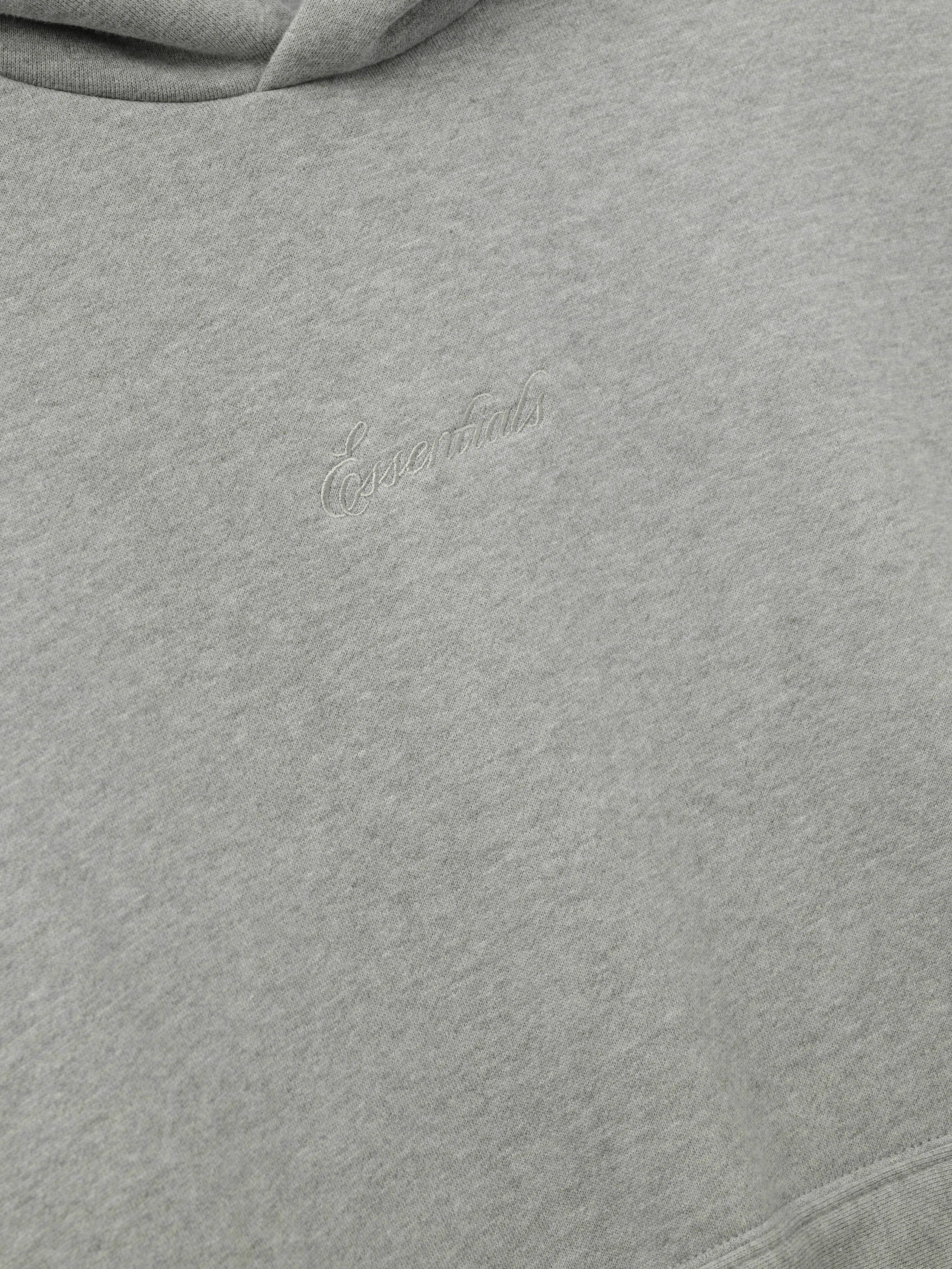 Gray hoodie with essentials embroidery on a white background