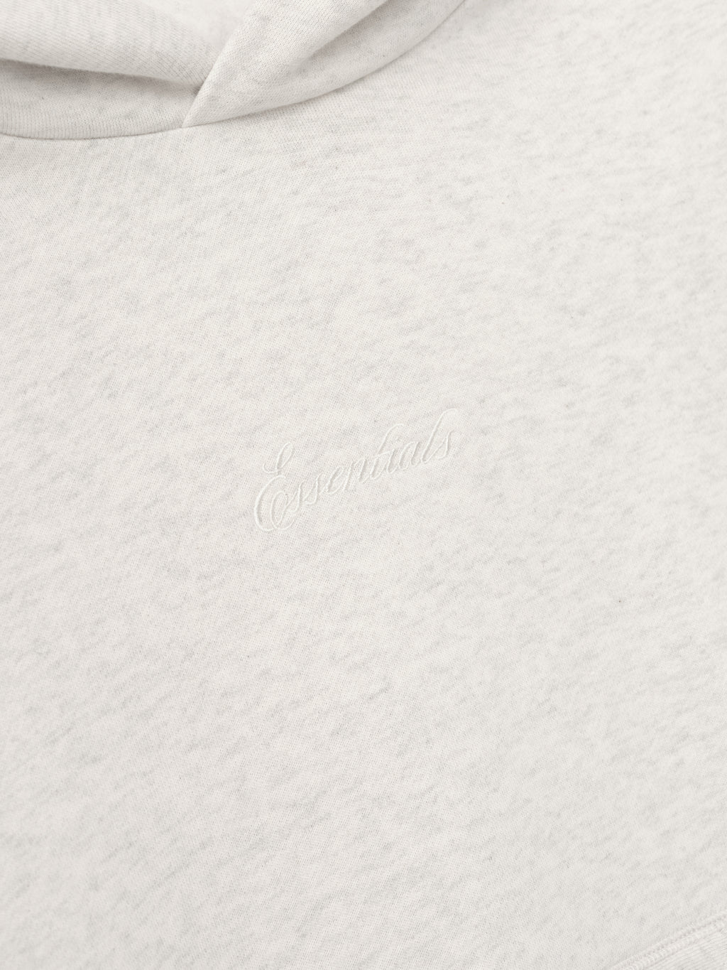 Close-up of textured white fabric with Essentials Embroidery