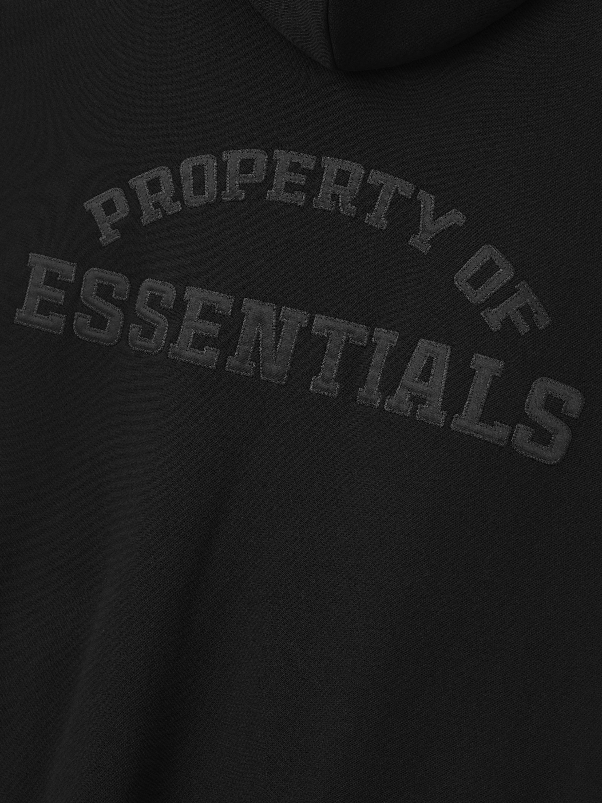 close-up of black heavyweight fleece hoodie with embossed Property of Essentials logo on back panel
