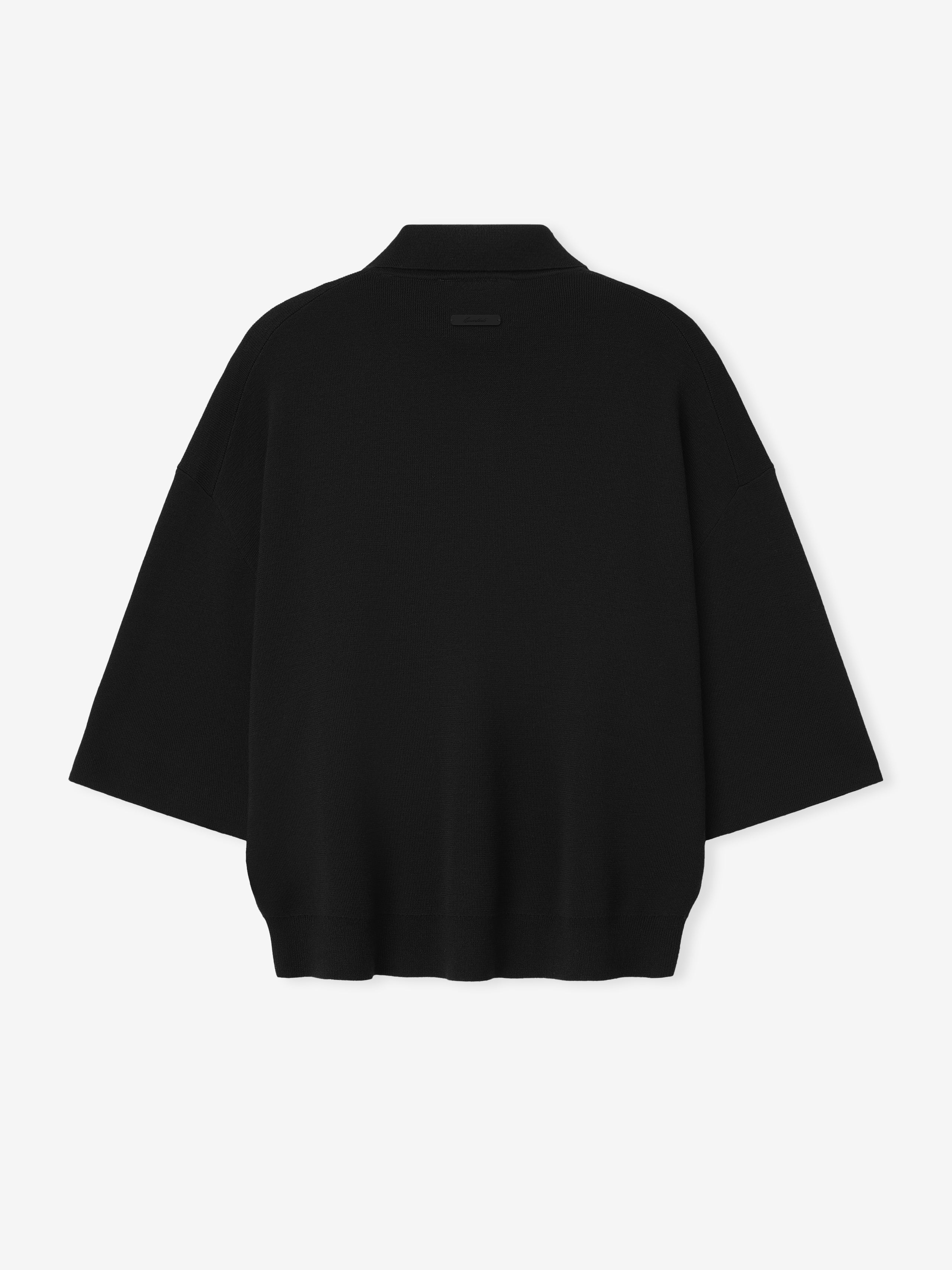 black heavy merino knit polo with relaxed fit and 3/4 sleeves, featuring a subtle signature label on the back neckline
