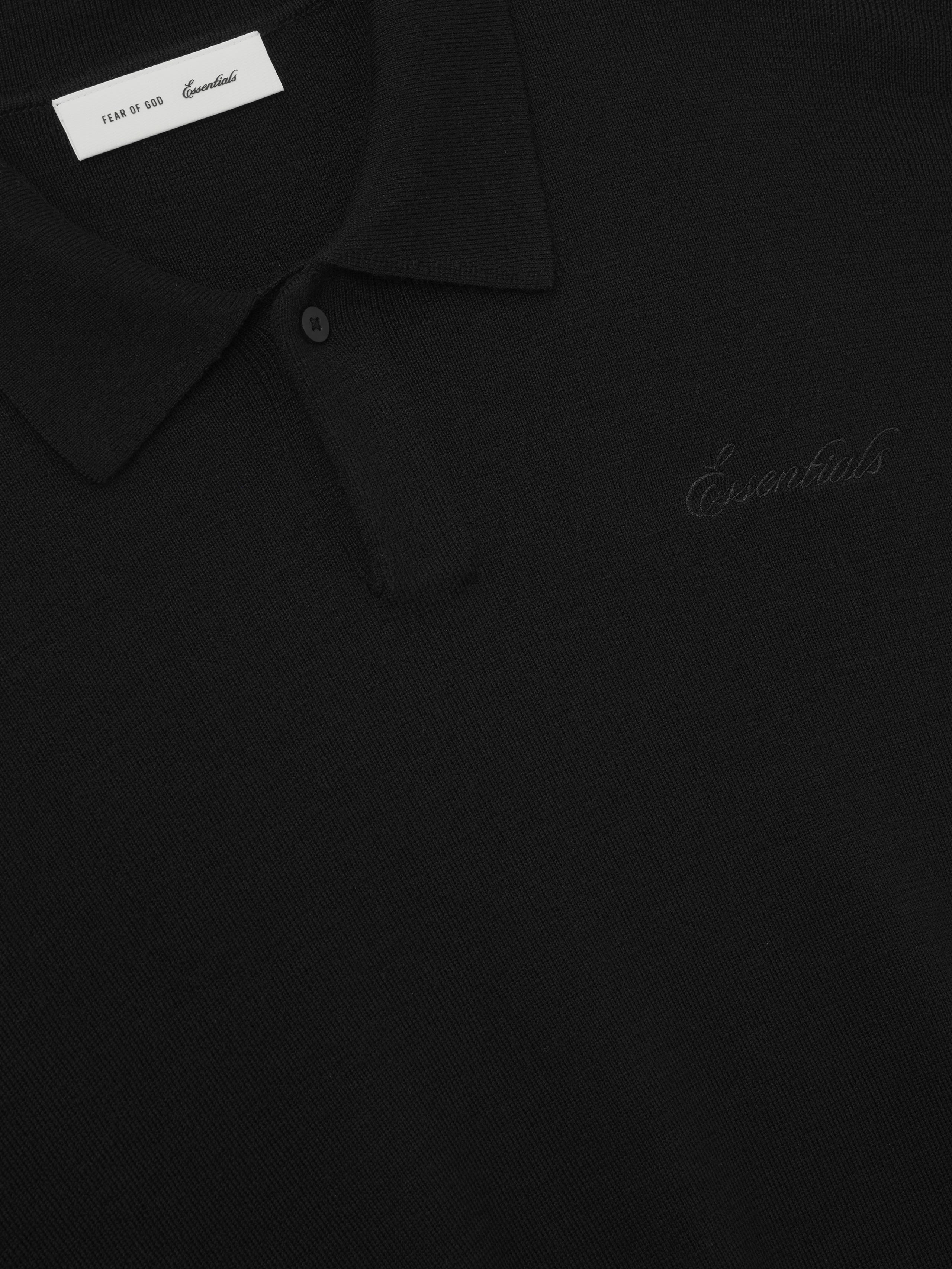 black heavy merino knit polo with subtle tonal Essentials embroidered script on chest and classic collar detail