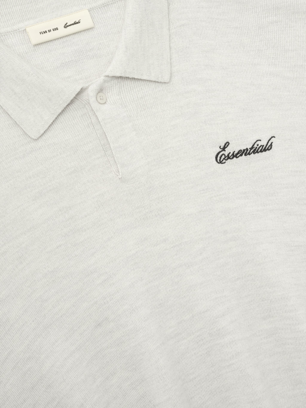 off-white heavy merino knit polo with classic collar and black Essentials script embroidery on chest