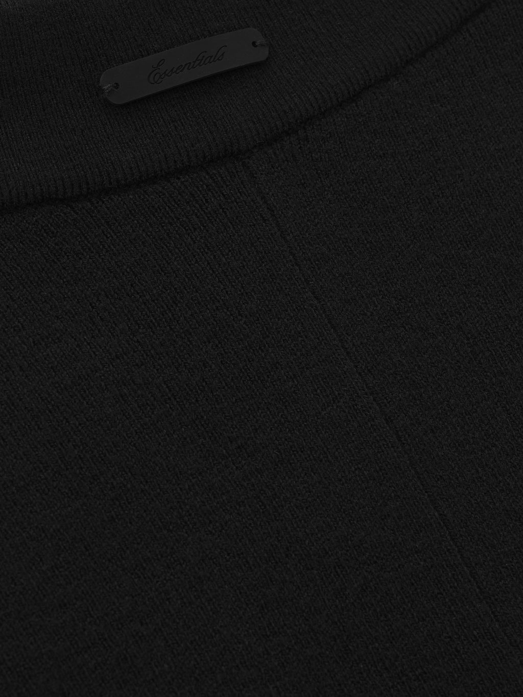 close-up of black rib knit fabric and small Essentials logo detail on waistband of women’s bike shorts