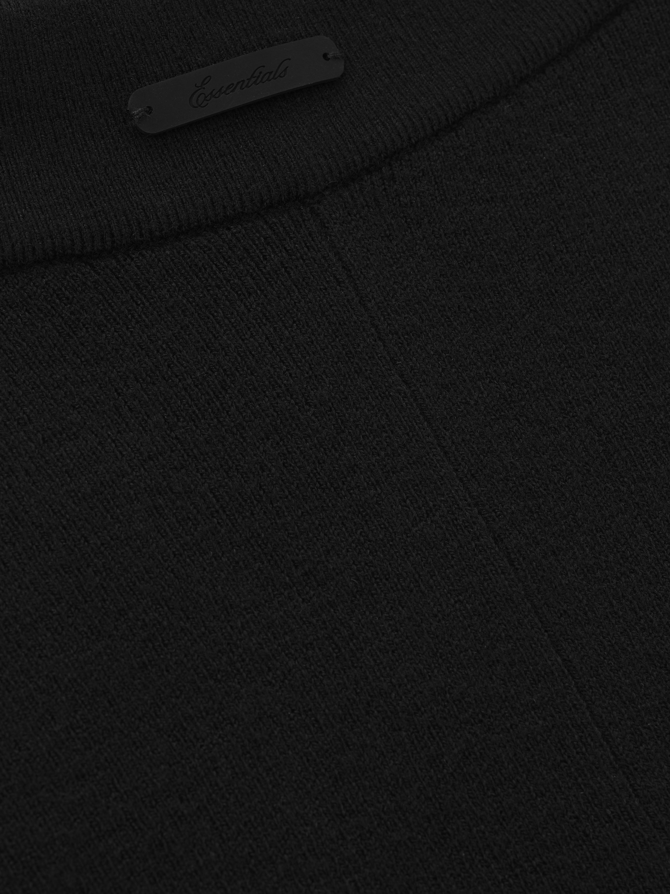close-up of black rib knit fabric and small Essentials logo detail on waistband of women’s bike shorts