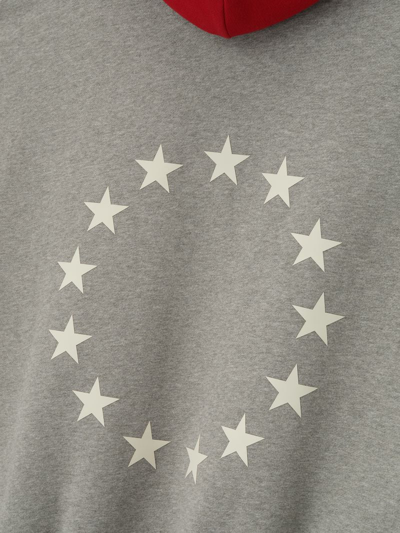 Close-up of grey Sixers Sport hoodie back featuring circle of white stars and red hood visible at top edge