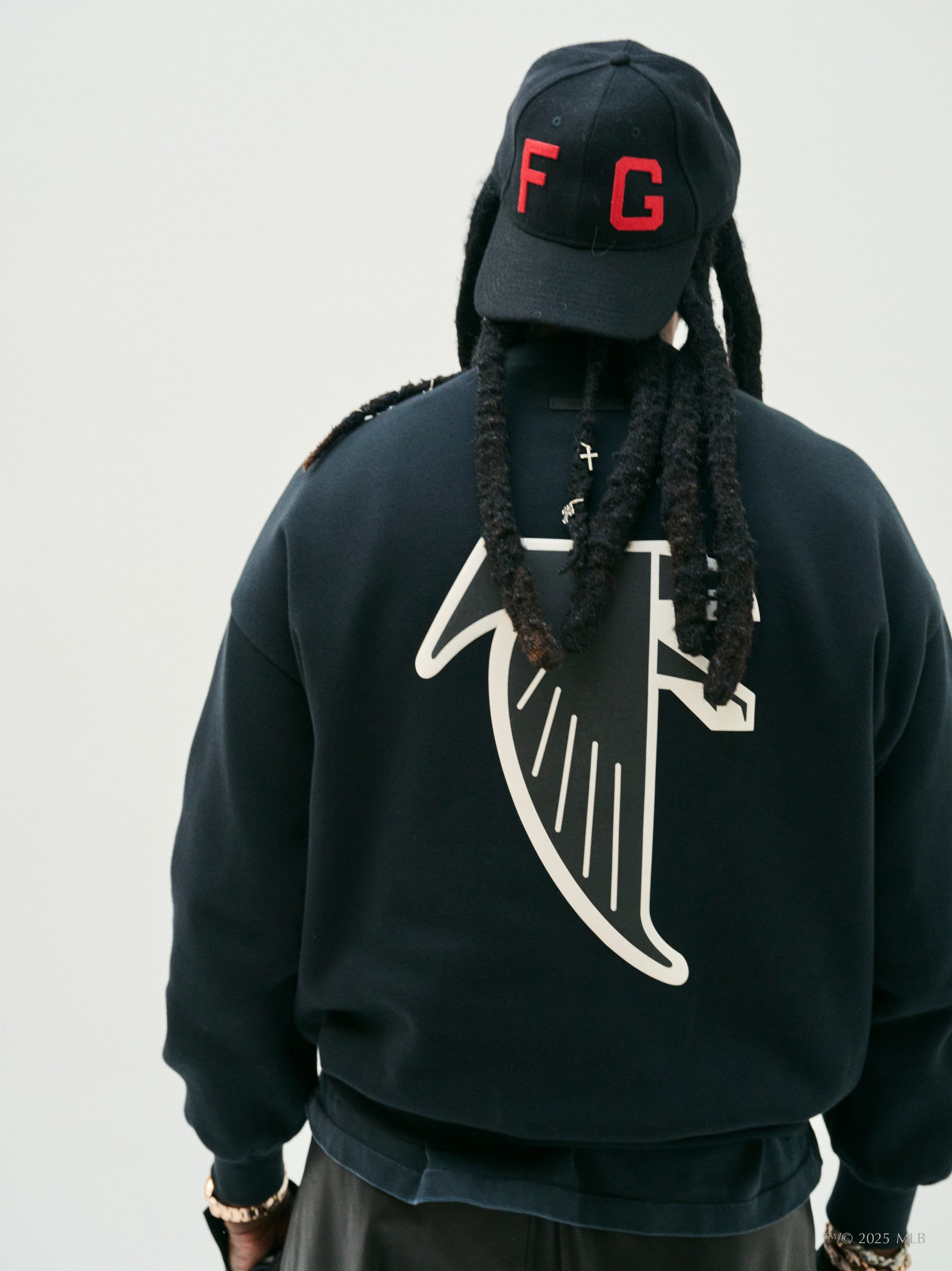 Back view of black Essentials Falcons crewneck featuring large white falcon wing graphic across fabric