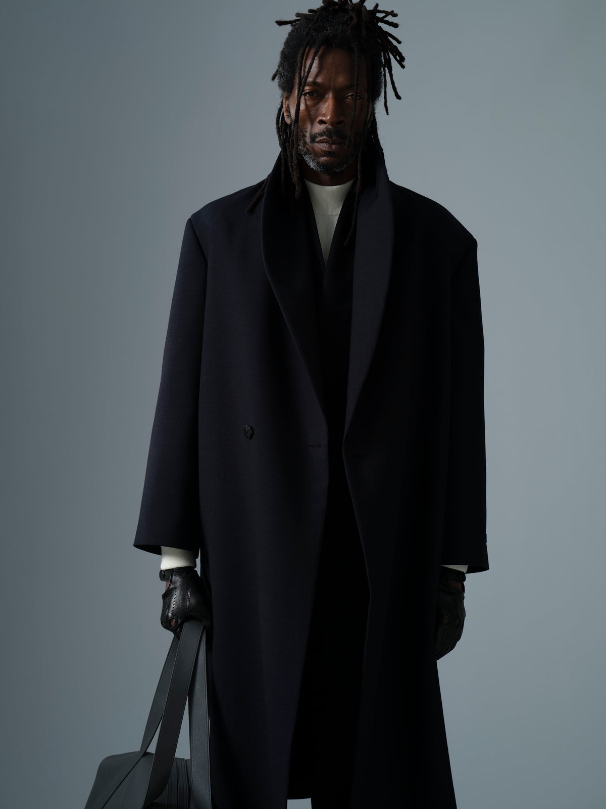 Double Weave Cotton Wool Shawl Overcoat in black shown worn as a long tailored outerwear coat with broad shawl lapels and a relaxed silhouette
