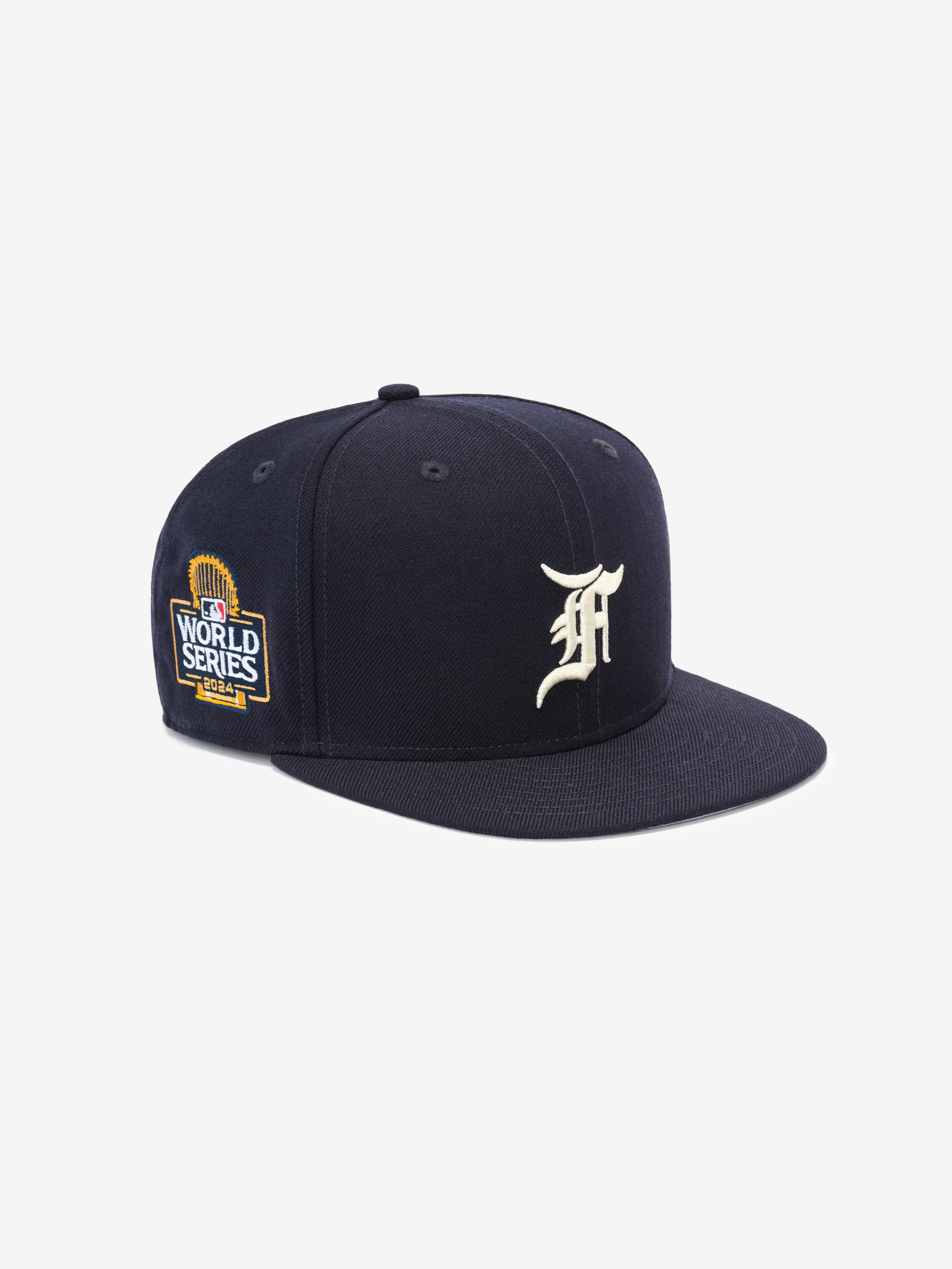 Navy blue structured baseball cap with white ornate letter on front and detailed World Series patch on side panel