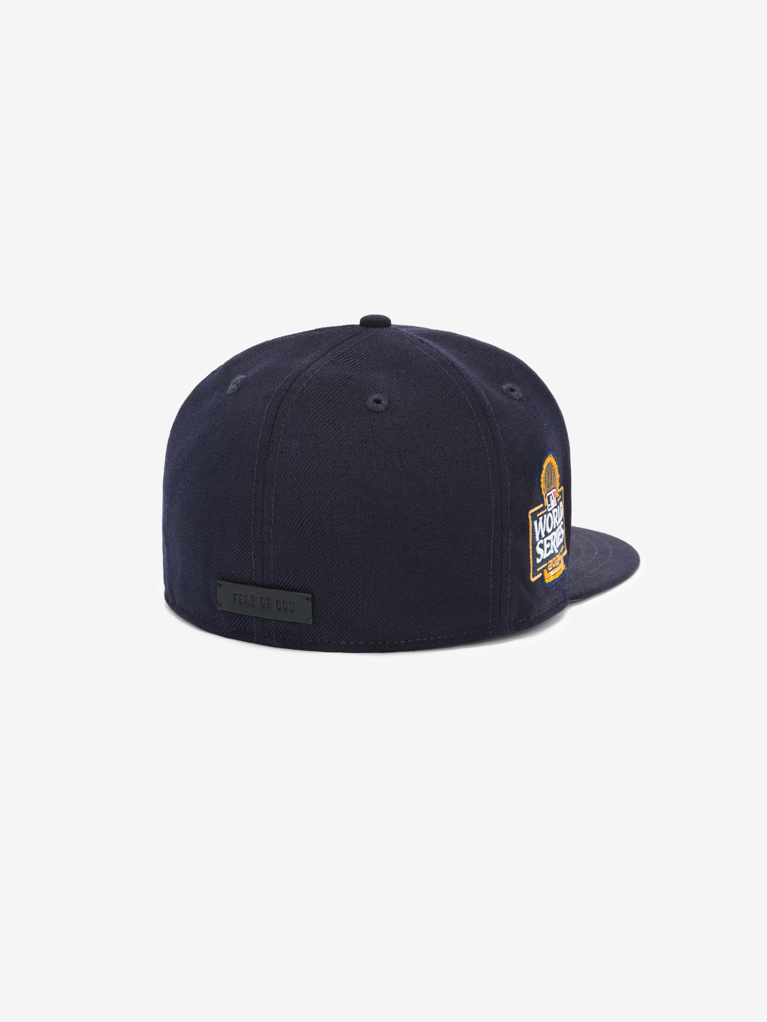 Rear angle of a navy blue cap featuring an embroidered World Series patch on the side and a black rear label