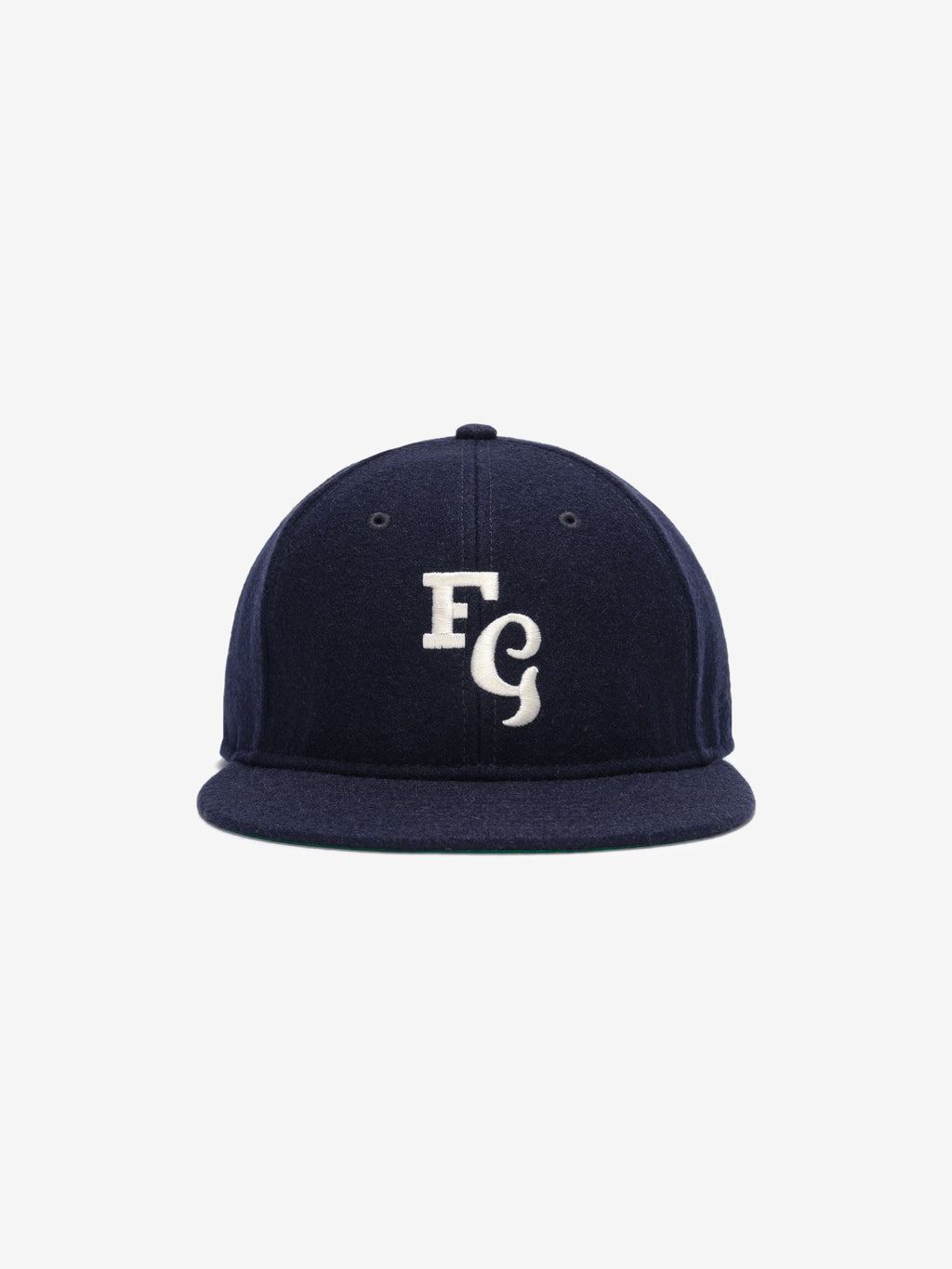 Fear of God Essentials 59FIFTY Retro Fitted FG Cap in deep navy fabric with a white embroidered interlocking "FG" emblem on the front and a structured flat brim.