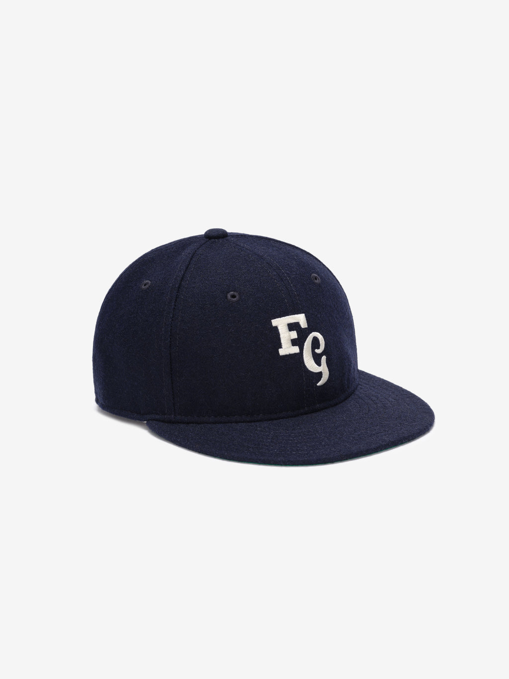 Fear of God Essentials 59FIFTY Retro Fitted FG Cap in navy fabric featuring a clean white embroidered FG logo on the front panel and a structured flat brim design.