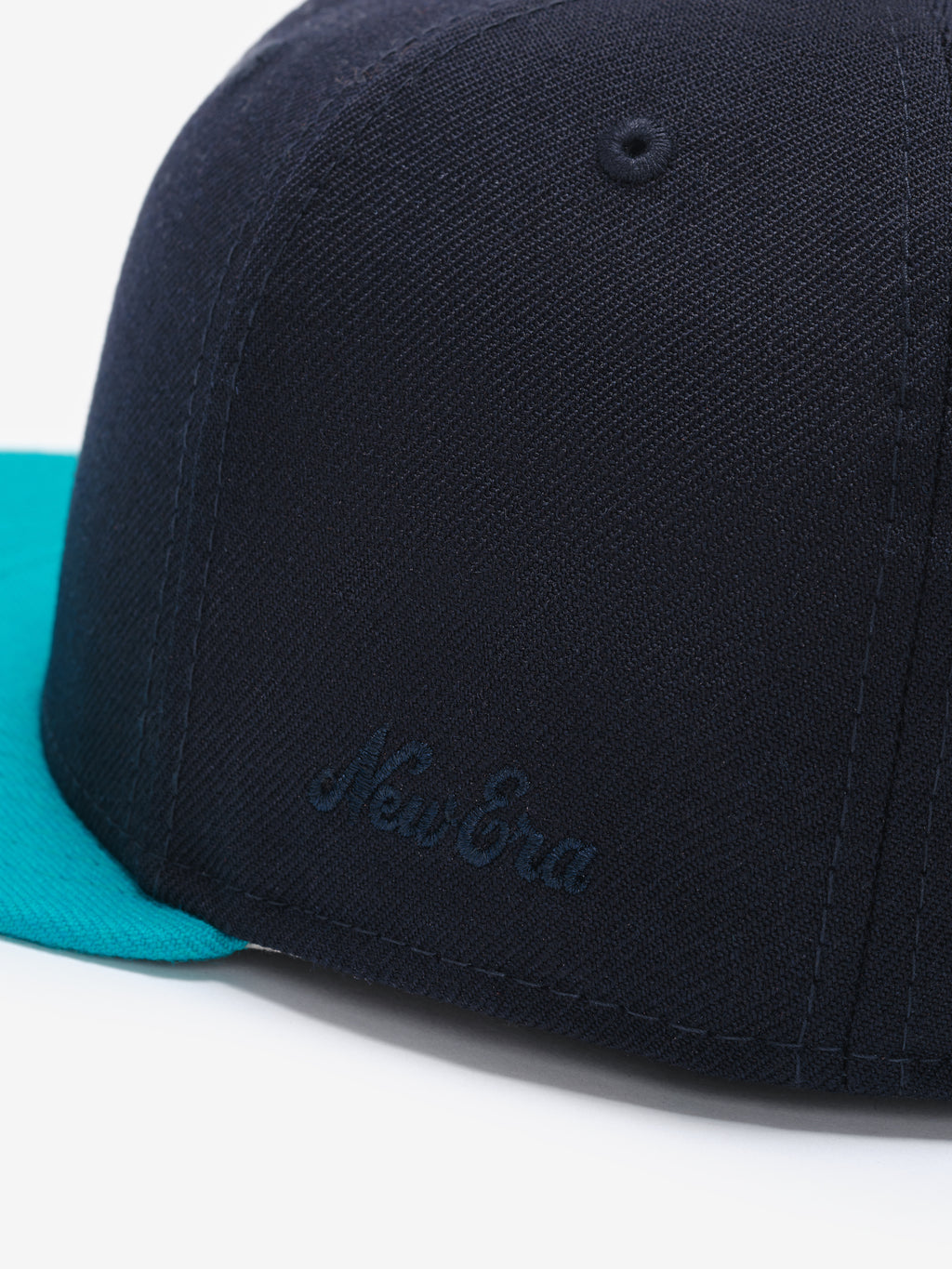 Fear of God Essentials 59FIFTY Athletics Cap in navy blue featuring a subtle tonal New Era logo embroidered on the side panel and a bright turquoise flat brim.
