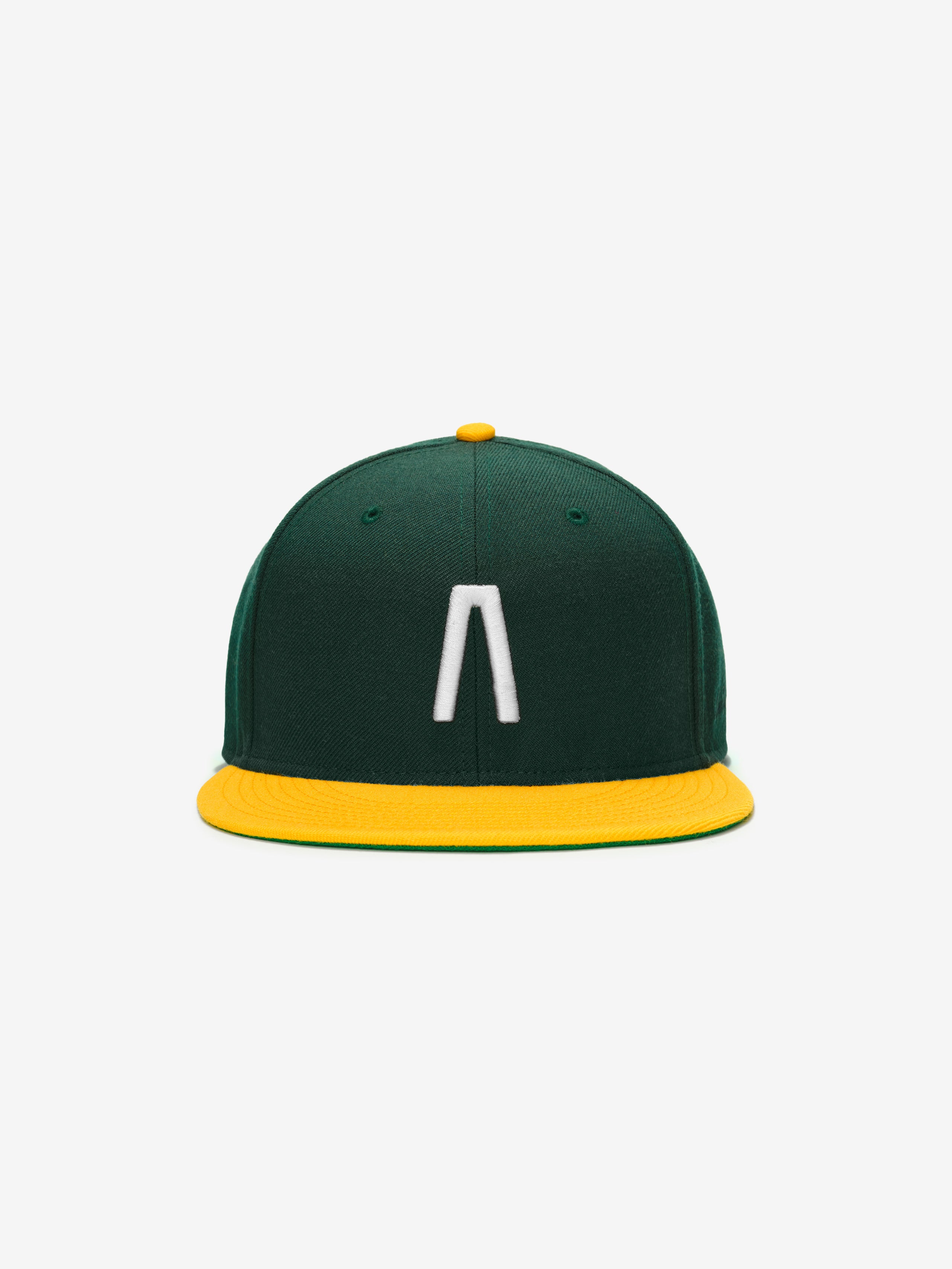 Fear of God Essentials 59FIFTY Athletics Cap in dark green with a bright yellow flat brim and button, featuring a raised white minimalist logo embroidered on the front panel.
