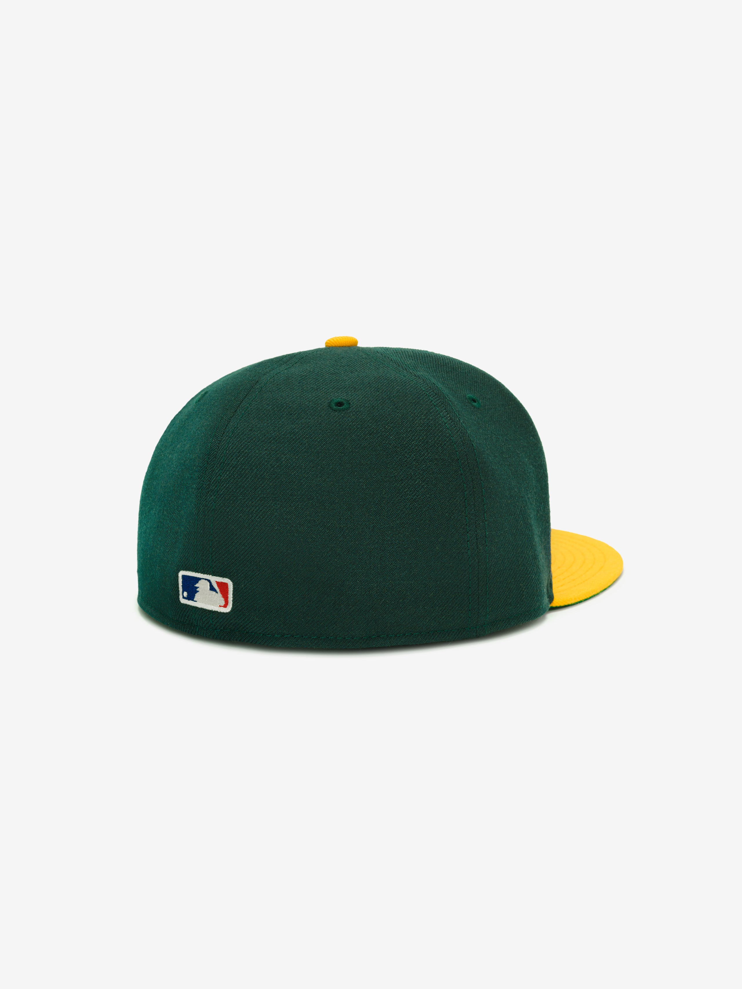 Fear of God Essentials 59FIFTY Athletics Cap shown from the back, featuring a dark green crown with a contrasting yellow flat brim and button, and a small MLB logo embroidered near the base.