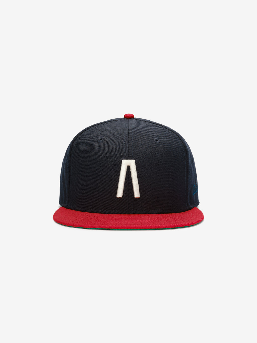 Fear of God Essentials 59FIFTY Athletics Cap featuring a navy blue crown with a prominent white embroidered minimalist symbol on the front and a contrasting red flat brim and button.