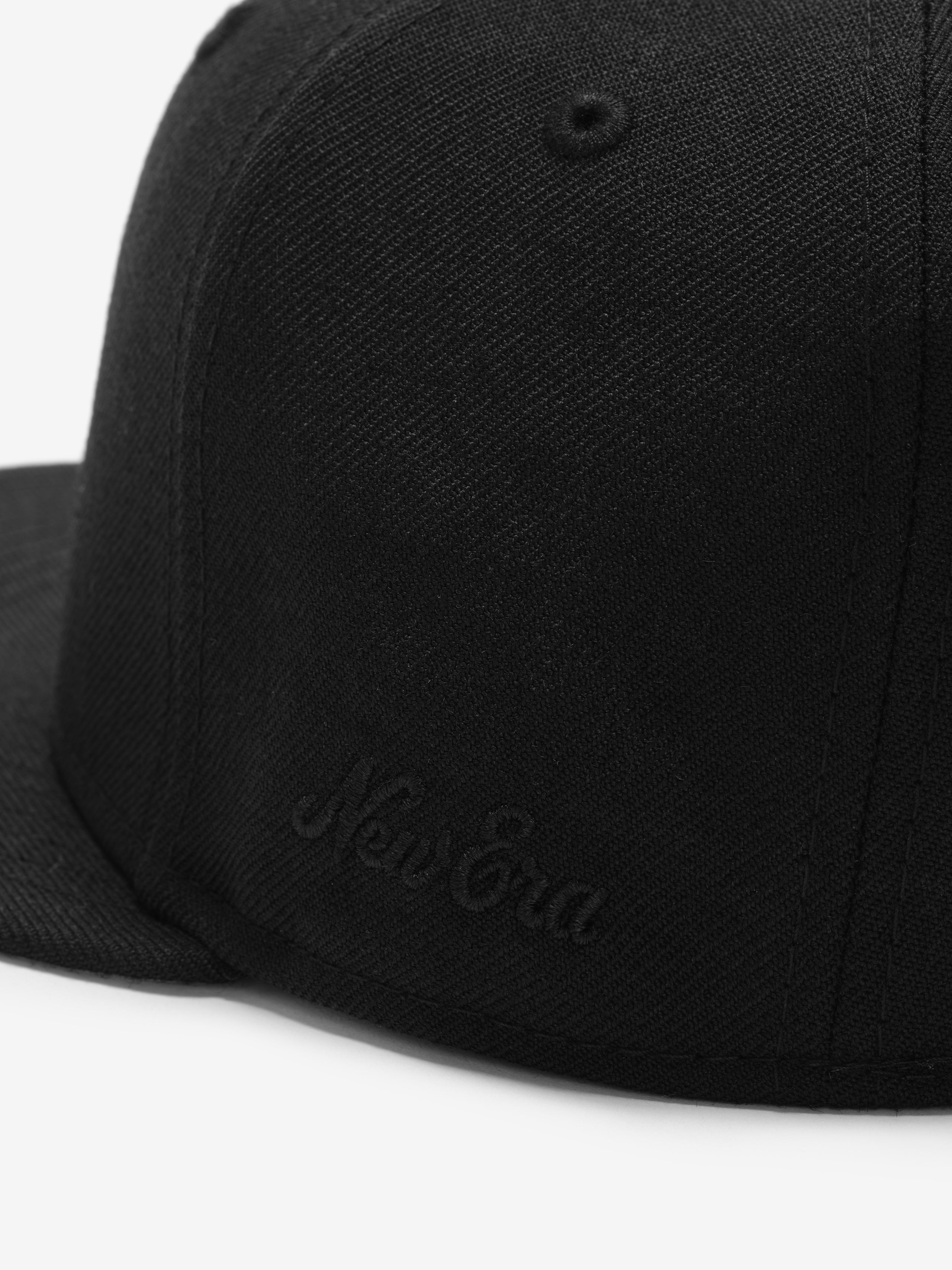 Fear of God Essentials 59FIFTY Athletics Cap featuring a sleek black fabric with subtle tonal embroidery on the side and a structured flat brim.