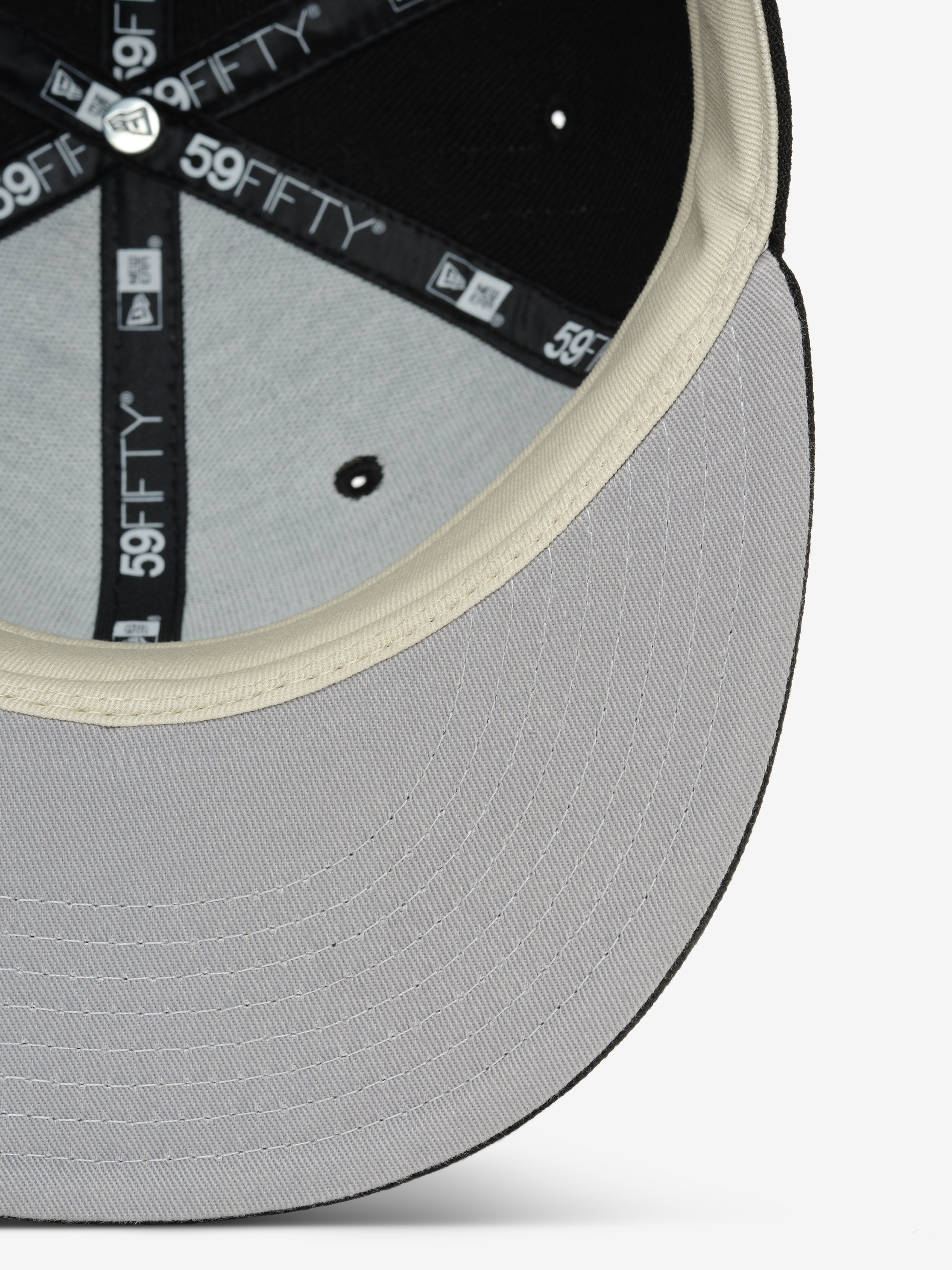 Fear of God Essentials 59FIFTY Athletics Cap showing the light gray underside of the brim with detailed stitching, cream inner sweatband, and black interior support with branded taping.