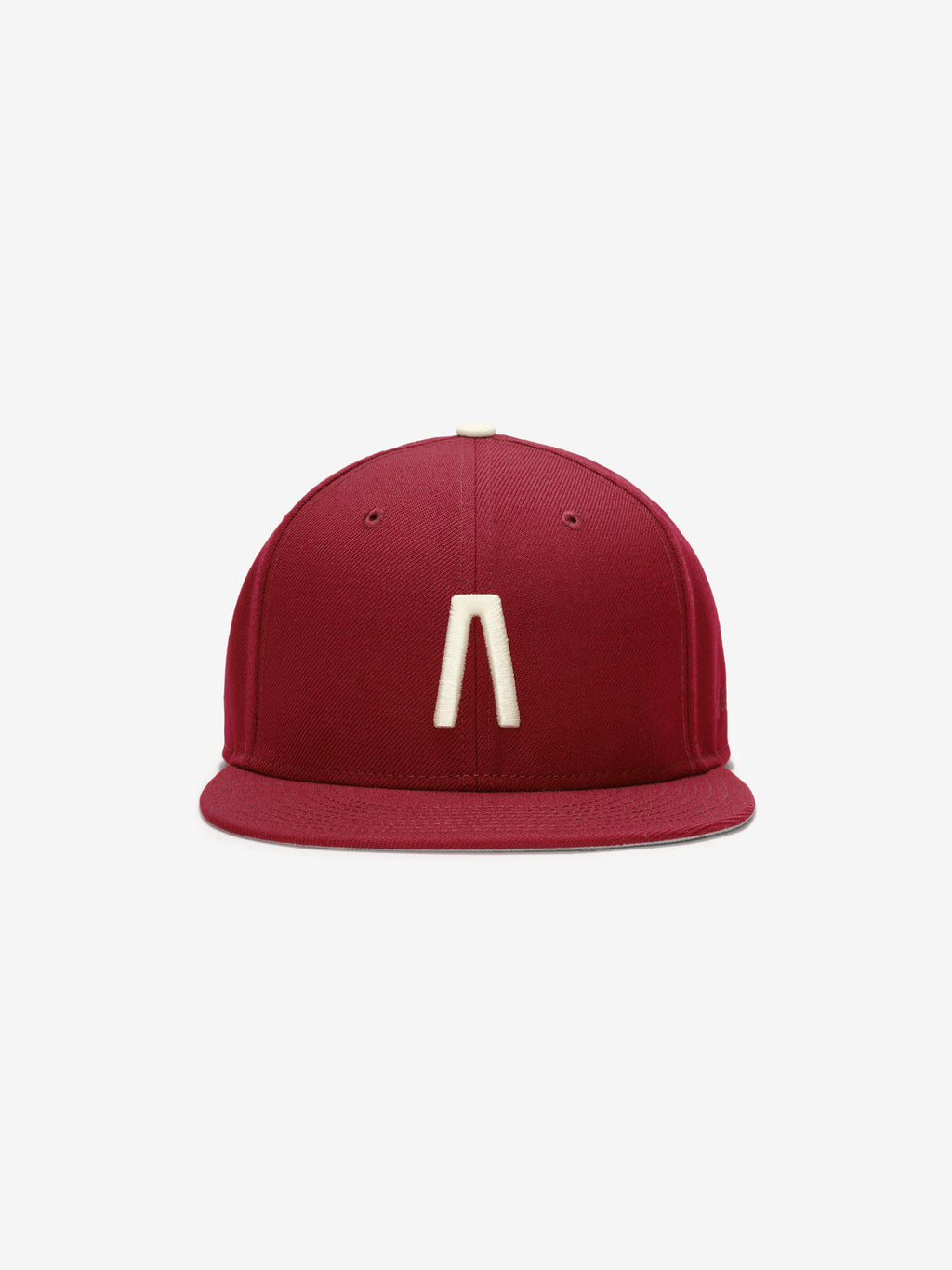 Fear of God Essentials 59FIFTY Athletics Cap in deep crimson featuring a minimalist cream emblem centered on the front panel with a structured flat brim design.