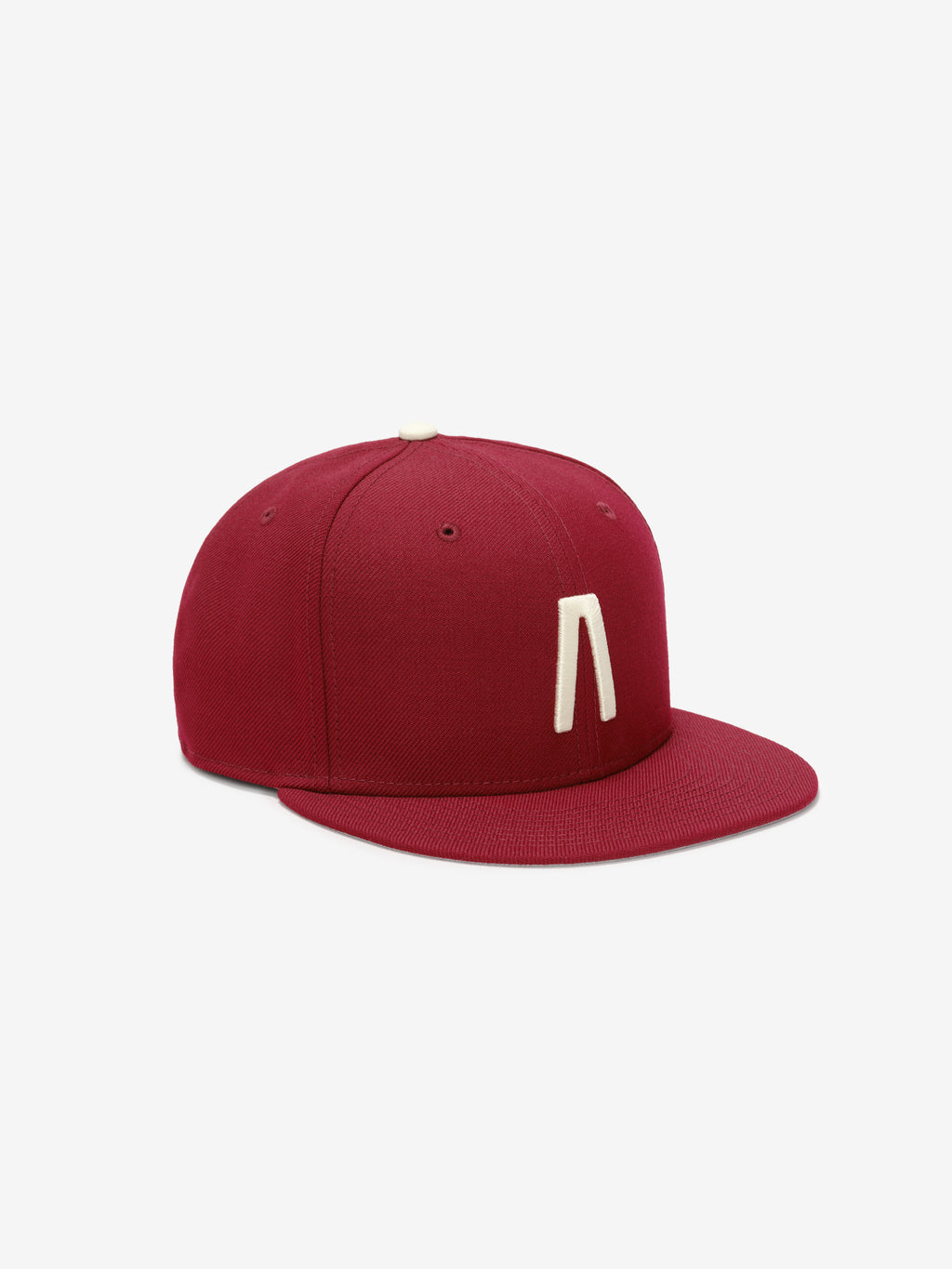 Fear of God Essentials 59FIFTY Athletics Cap in rich crimson fabric, featuring a minimalist cream emblem on the front panel and a structured flat brim design.