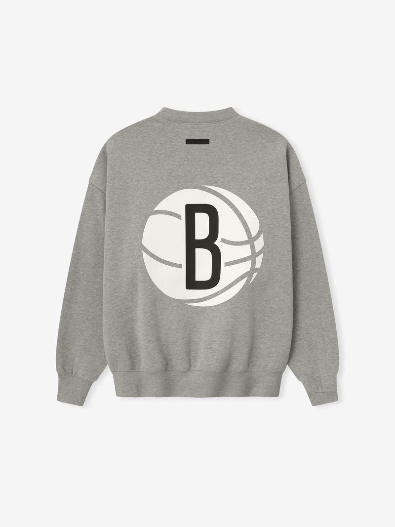 Back view of grey crewneck featuring large white basketball graphic with bold black letter B in center