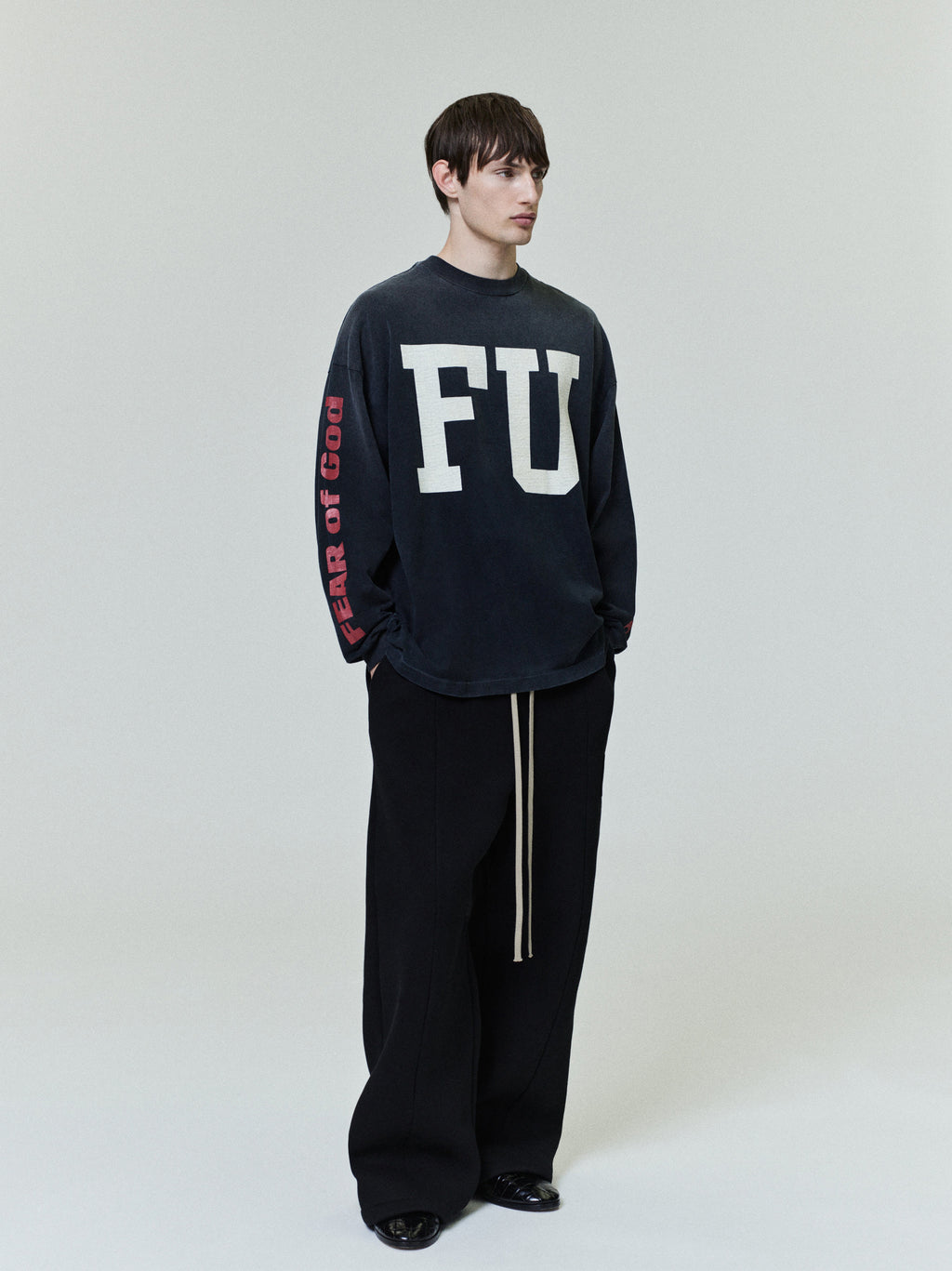 Freedom Relaxed Long Sleeve Tee in black featuring large white “FU” lettering on the front and red “Fear of God” text down the sleeve, designed for a casual tops look.