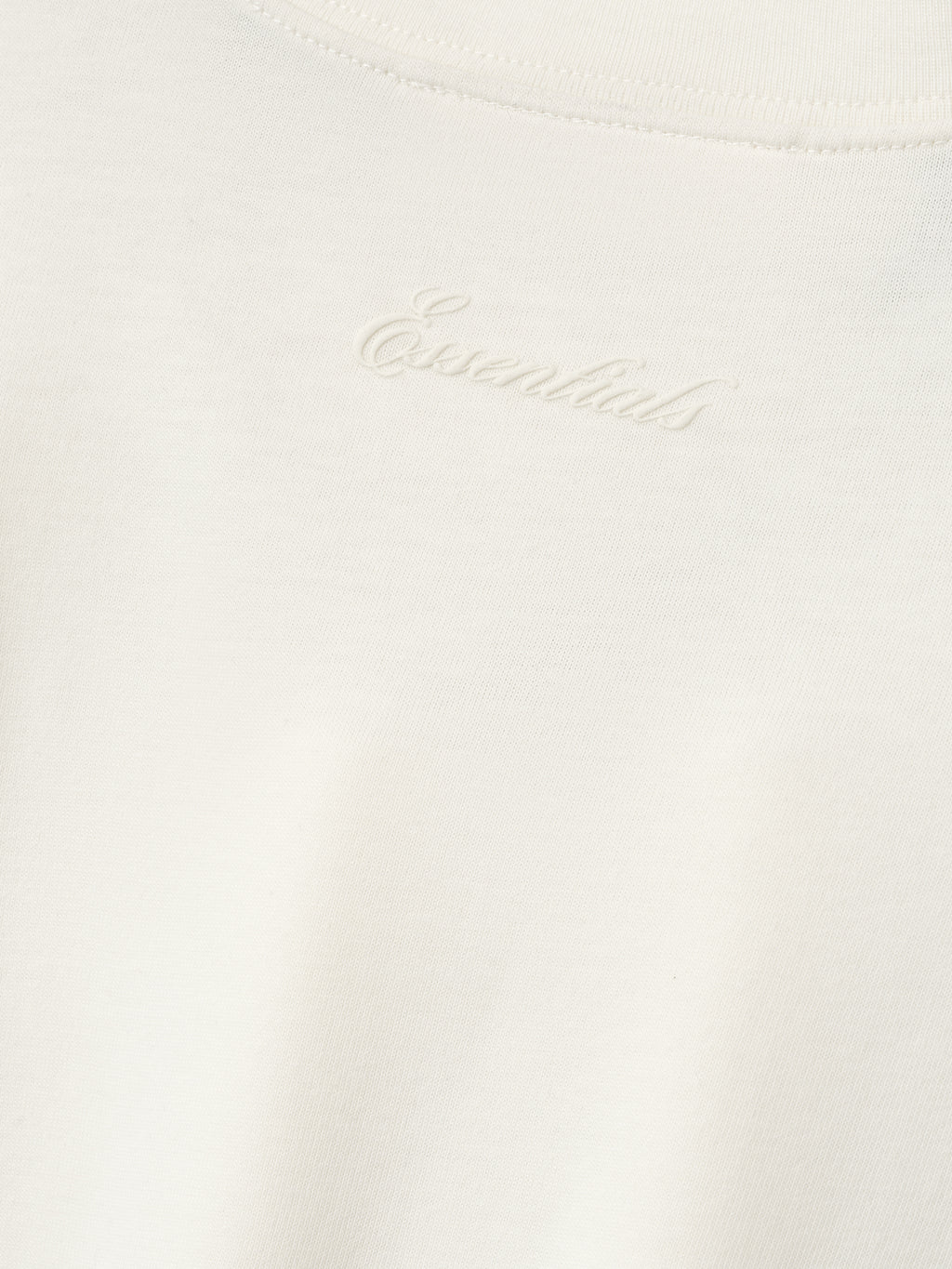 close-up of off-white cotton blend jersey fabric with subtle puff-printed Essentials logo at back neckline