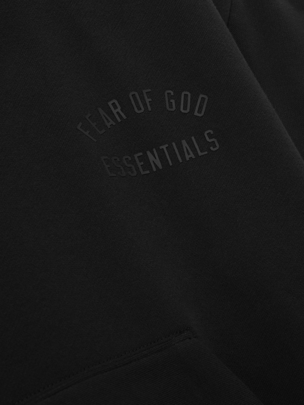 Black sweatshirt with 'Fear of God Essentials' text on a black background