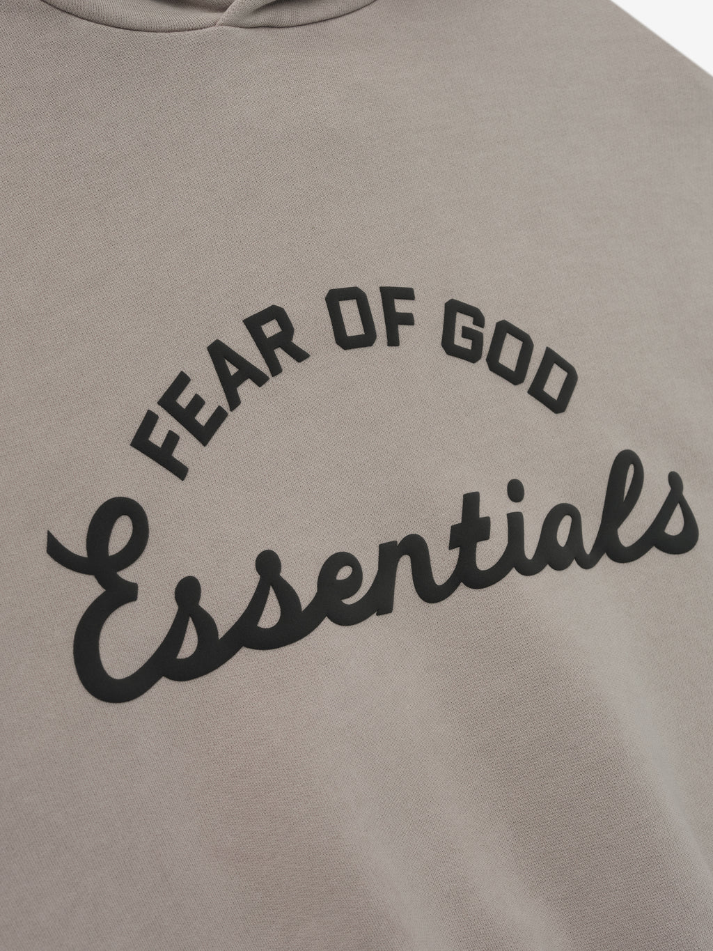 close-up of muted taupe kids hoodie with curved Fear of God Essentials logo printed in black on front
