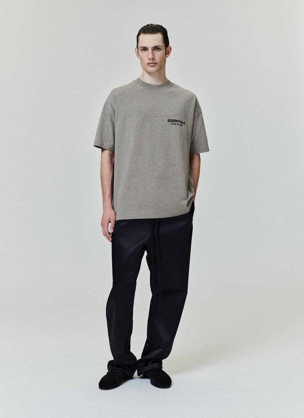 Model wearing Homestead Heather Classic Short Sleeve Tee with small black ESSENTIALS Fear of God logo on chest, gallery image 0