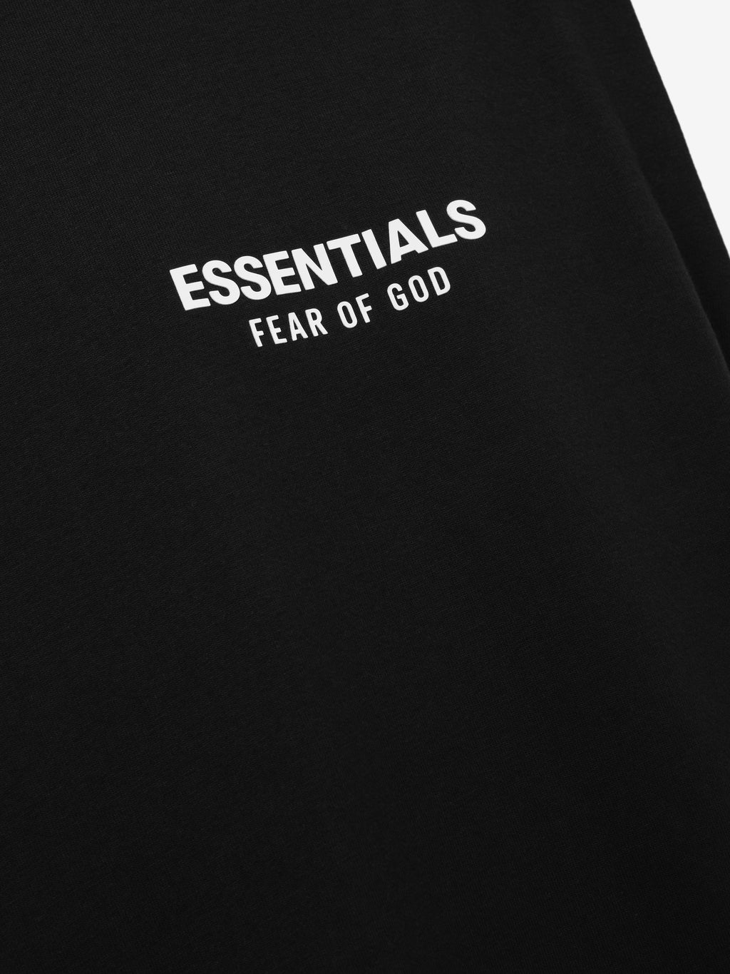 Essentials FW26 Classic Cut-Off black garment close-up with a white Essentials Fear of God logo printed on the fabric in a Tops product view
