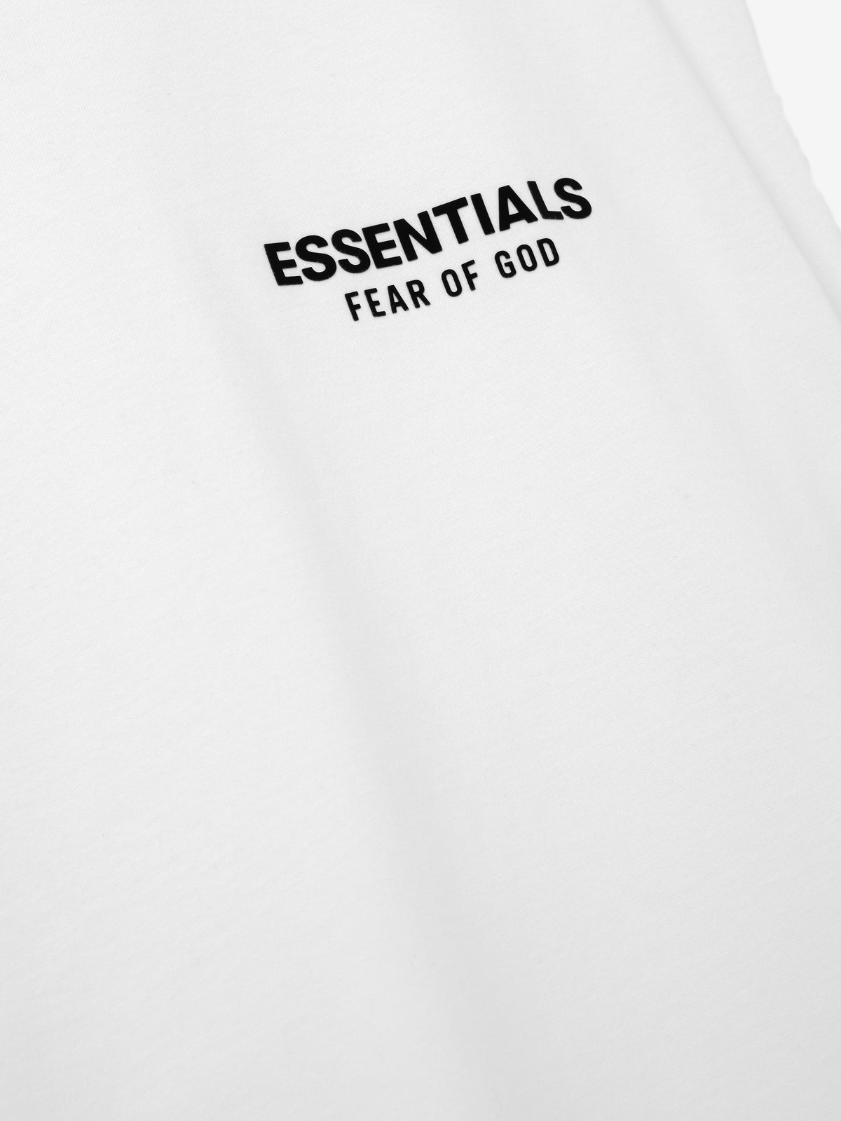 Essentials FW26 Classic Cut-Off white fabric close-up featuring a black Essentials Fear of God chest logo in a detailed Tops product view