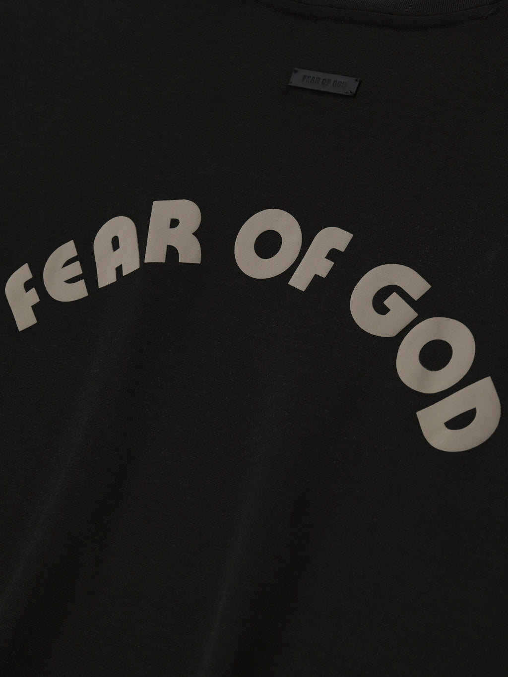 black cotton-rayon tee with large arched "FEAR OF GOD" lettering in off-white across the front chest