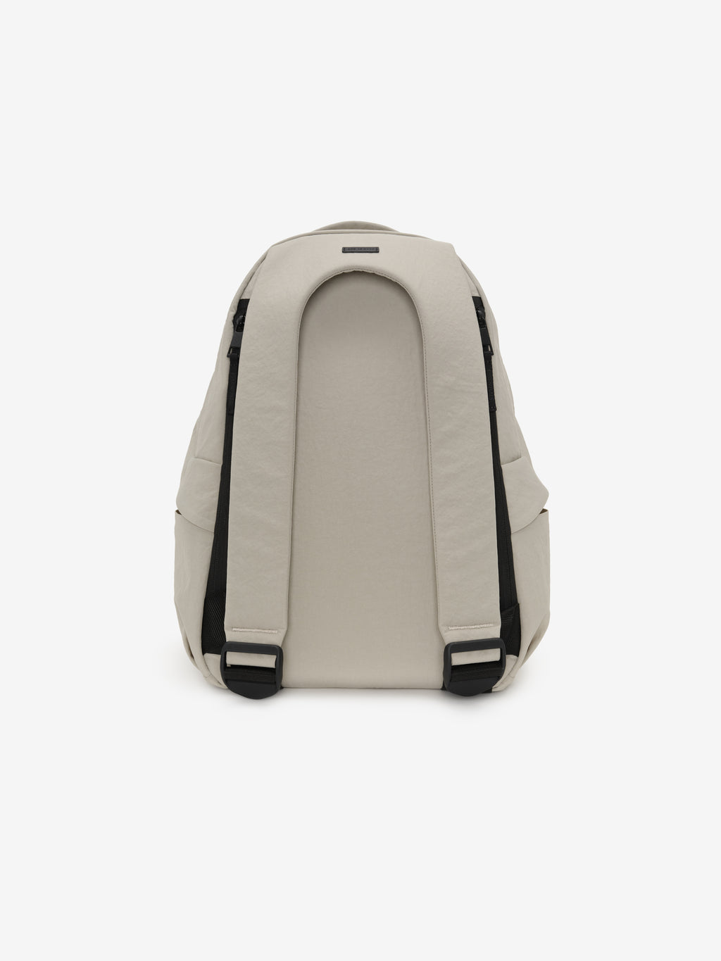 Essentials Backpack in beige shown from the back with padded shoulder straps black adjustment buckles and a curved rear panel against a clean white background