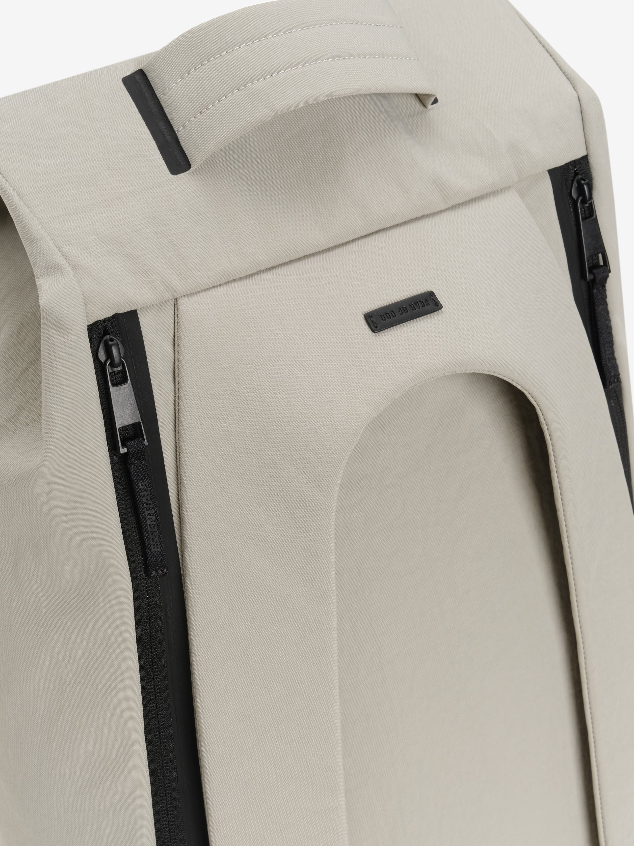 Sports Duffel in light gray close up showing a padded top handle black vertical zippers curved front pocket and subtle logo patch on smooth textured fabric