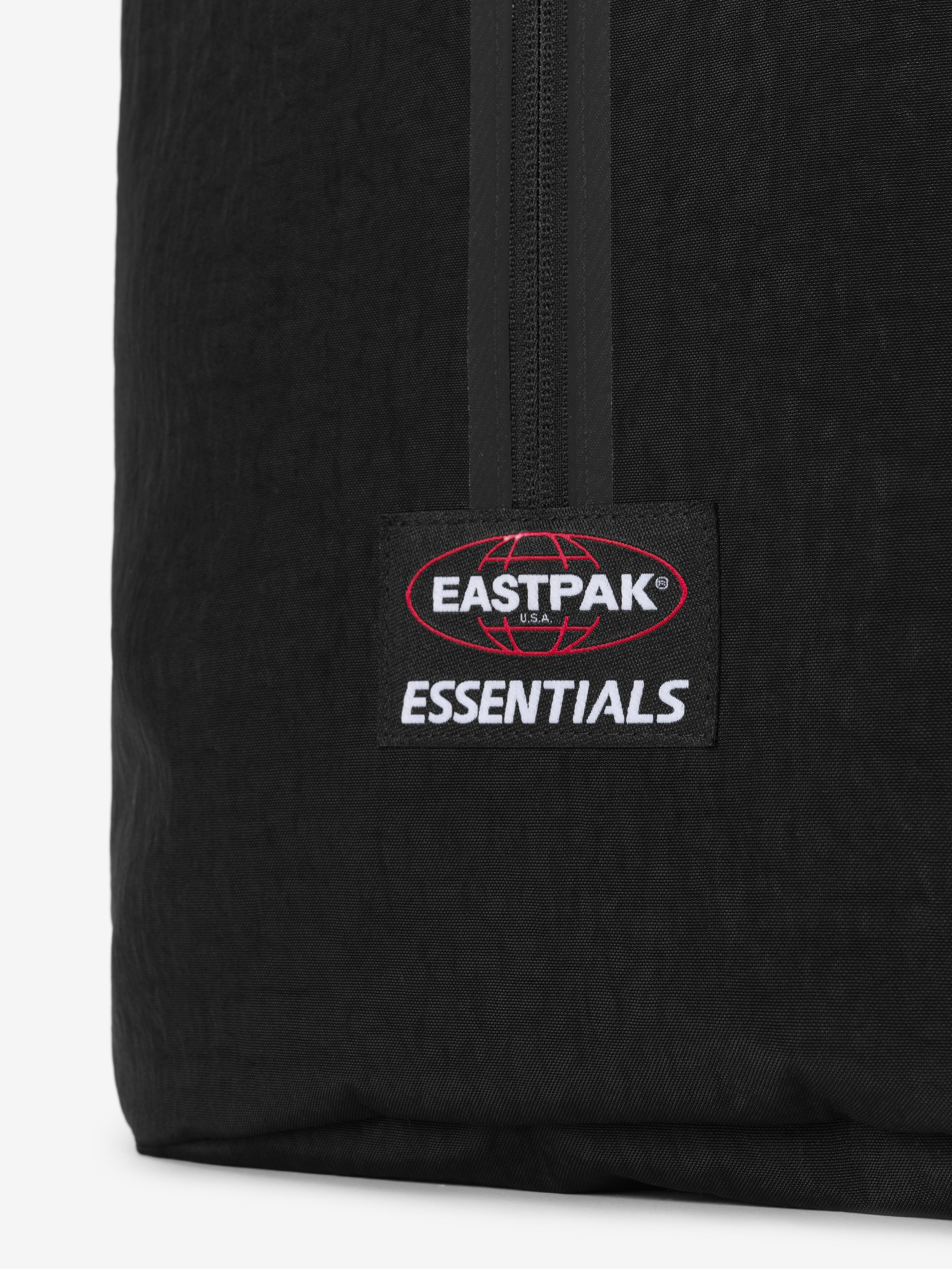 Sports Duffel in black featuring a central zipper and Eastpak Essentials logo patch on textured fabric against a clean white background